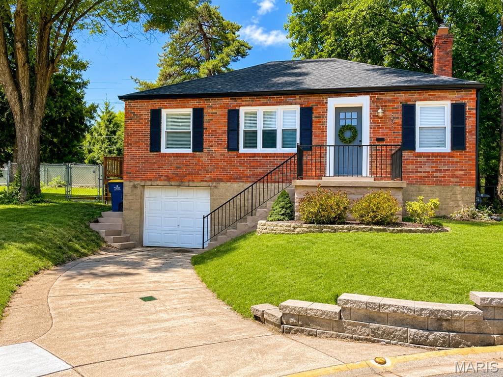 Showings will begin July 6th.
Located on a private cul-de-sac in the highly desirable Webster Groves School District, this fully renovated brick bungalow in Rock Hill offers a perfect blend of charm and modern updates. Thoughtfully redesigned by a master carpenter and artist/designer duo, the home features a stunning custom kitchen with 48-inch white cabinetry, concrete countertops, subway tile backsplash, farmhouse sink, and stainless steel appliances, opening to a bright and spacious living and dining area. The main level includes two large bedrooms and an updated bath with a handcrafted walnut vanity, subway tile surround, and slate flooring, with hardwood floors throughout. The lower level provides additional living space, laundry/storage, and a walkout to the backyard, along with a tuck-under garage. Enjoy a fully fenced, private backyard with deck, patio, fire pit, and garden space ideal for entertaining. Conveniently located near shopping, dining, and Highway 40.