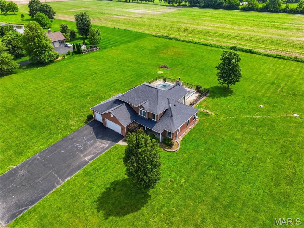 Welcome to Arbor Ridge, where country living meets comfort and convenience in the highly sought-after Waterloo School District. Situated on 3 acres with breathtaking country views, this spacious two-story home offers room to spread out both inside and out.

Step through the front door into the formal dining room, then continue into the impressive two-story great room featuring soaring vaulted ceilings, oversized windows that flood the space with natural light, and a cozy wood-burning fireplace. The updated kitchen offers an eat-in dining area, walk-in pantry, and easy access to the mudroom and laundry area.

The main-level primary suite provides a private retreat with a spacious bathroom featuring a dual vanity, soaking tub, separate shower, and walk-in closet. Upstairs, you'll find three additional generously sized bedrooms, two with walk-in closets, along with a full bathroom.

Outside, enjoy summer days in the fenced inground pool area while taking in the beautiful countryside views. The deep 3-car attached garage provides plenty of storage, and a separate garage entrance leads directly to the unfinished basement. The basement offers endless possibilities and includes drywall and framing lumber that will remain with the home, as previous plans were made to finish the space.

Recent updates include a new roof (2022), new pool liner (2022), and a new pool pump and sand filter (2023). If you've been searching for space, views, and a fantastic location, this home in Arbor Ridge is one you won't want to miss.