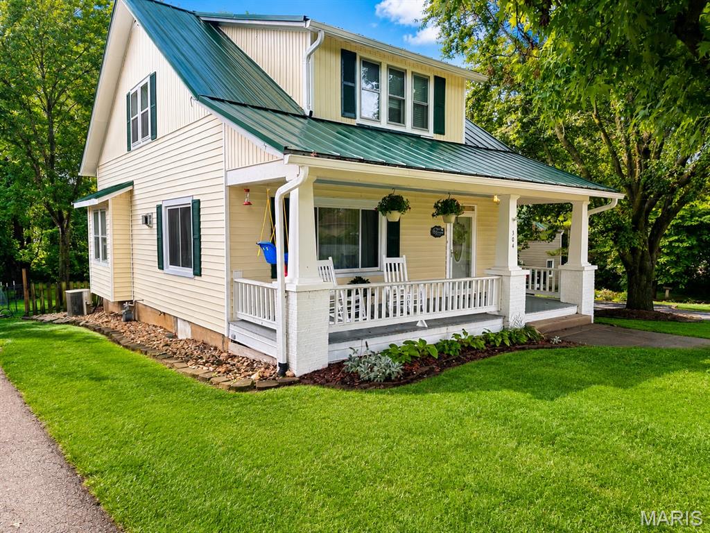 Welcome home to this beautifully updated 1.5-story charmer nestled on over a half-acre in the heart of New Haven! Blending timeless character with modern conveniences, this 2-bedroom, 2.5-bath home offers updated and inviting living space plus a partially finished lower level featuring a spacious rec room, office, bathroom, and laundry area. Rich hardwood and tile flooring, large picture windows, solid surface kitchen countertops, and an oversized primary suite with generous closets and built-in organizers make everyday living both comfortable and functional. Original details—including exposed brick, a laundry chute, and the historic detached barn—preserve the home's character while thoughtful updates such as newer windows, updated electric service, standing seam metal roof, and luxury vinyl plank flooring in the lower level provide peace of mind. Relax on the welcoming covered front porch behind the classic white picket fence, entertain on the covered rear deck, or enjoy the privacy of the beautifully landscaped backyard shaded by mature trees. A detached two-car garage, original barn with electric, workshop space, and attached carport offer exceptional storage and endless possibilities for hobbies or projects. Conveniently located with easy access to Hwy. 100 and just minutes from Washington, Hermann, local wineries, parks, shopping, and dining, this move-in ready home offers the perfect blend of small-town living and modern comfort. Homes with this much charm, outdoor space, and character don't come along often—schedule your private showing before it's gone!