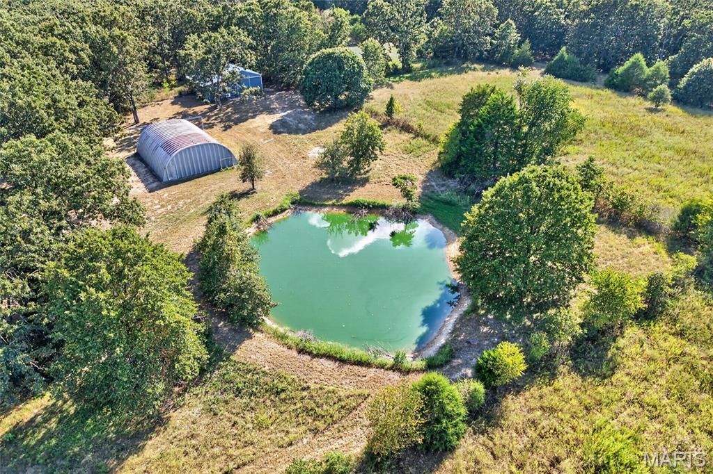 Over 11 beautiful acres of privacy, possibilities, and country charm await! This incredible property is ready for you to bring your dream home to life, with so many of the hard and expensive pieces already in place. Mature trees create a peaceful, private setting, while electric service and well water are already established, offering significant savings and convenience for the next owner. A driveway is already in place, making access to the property easy from day one. Need a possible place to stay while building? The existing 1887 sqft. Quonset is equipped with electric and heat, offering the potential for temporary living quarters while your dream home takes shape. Equestrian enthusiasts will love the approximately 30’ x 40’ horse barn, featuring multiple stalls, a concrete floor, and a spacious 16’ lean-to. Some fencing is already installed, making this property even more ready for your animals and country lifestyle. And then there’s the pond. Surrounded by natural beauty, it adds an incredible element of serenity to this already special property. Fruit trees are also scattered, adding even more charm. With multiple potential building sites, off black top, established utilities, a driveway, barn, Quonset, fencing, pond, mature trees, and over 11 acres to call your own, the possibilities are truly endless. You couldn’t recreate all that this property offers for the asking price. The groundwork is already done. The setting is already here. Now, it’s waiting for YOU to bring your dream home to life. Come walk the property, imagine the possibilities, and fall in love with your next chapter!