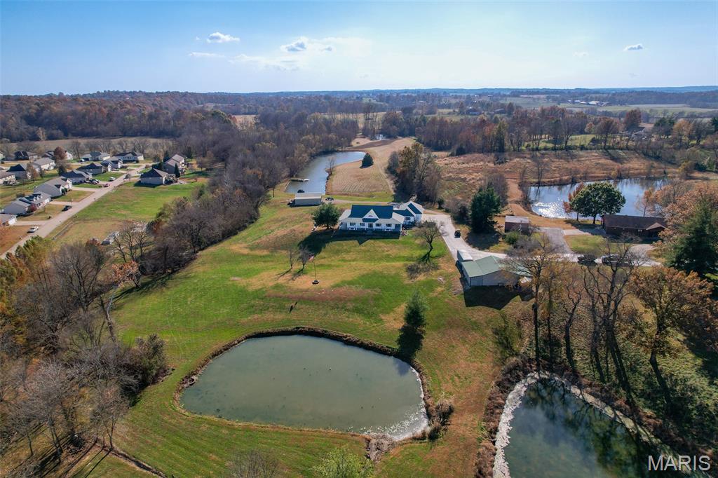 Outdoor Living Country Estate  
This Outdoor Living Country Estate Home is located just 2 miles outside of Jackson City limits, set on 19.07+/- acres and features an end-of-the road privacy with three stocked ponds, a separate shed with living quarters, a barn, and a live water creek.
All this is included with another potential build site for those who may be seeking a multi-family property. 
Nestled on this expansive land tract is an impressive four-bedroom, four-bath residence boasting approximately 3,992 square feet of living space. The home features custom quality cabinetry not only in the kitchen, but with built-ins throughout all the living areas. This traditional home offers the convenience of main-level laundry, a fireplace in great room, a formal dining room, a spacious three-car garage, and a Generac whole-house generator to always ensure that you have electric power. There is a fully finished walk-out basement, providing ample room for entertainment, recreation, and an additional living quarters for larger families, extended family, or visiting guests. 
Designed for both comfort and style, the house also provides for an enjoyable outdoor living space with a covered deck just outside the master bedroom, perfect for relaxing evenings or morning coffee while overlooking the picturesque landscape. Additionally, there is a large outdoor entertainment area with a covered Pergola and a sitting area to host guests.  Every detail in this home is crafted to blend modern luxury with the tranquility of country living, making this estate a truly exceptional find.
Back outdoors, there is a bonus 30’x50’ shop house with a kitchenette, shower, and bathroom.  There is also a 40’x50’ barn providing open space for storage or could be easily built out to support livestock or animals.  Or could easily be converted into horse stalls, a feed room, and a tack room, along with adding some basic outdoor fencing to create a perfect horse property.  Each building features a concrete floor throughout. 
This high-end estate country home, located within the desirable Jackson R-2 school district, provides for the outdoor spacious living that many are seeking in the county, yet a quick drive to town.