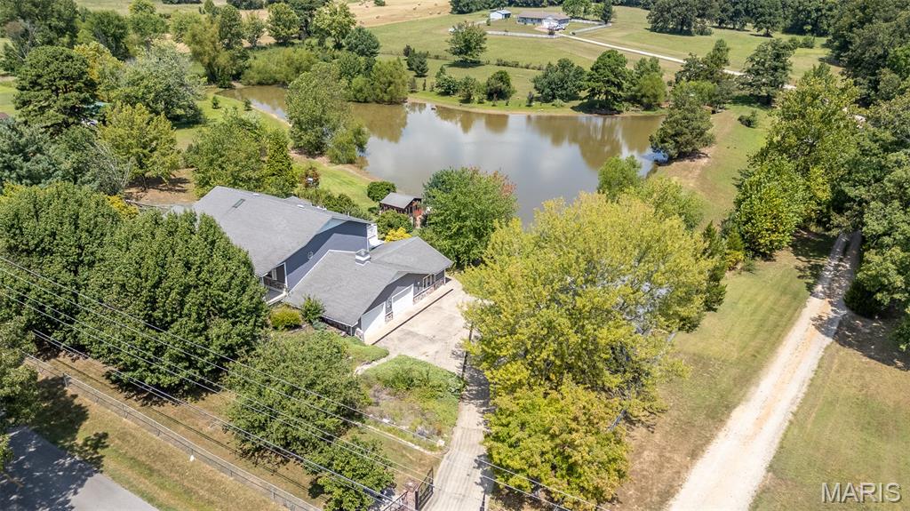 This is a one of a kind property. This can be a multi-family home, a single family home or an amazing vacation rental. Take your pick. There are 3 separate living areas. Two on the main level and one on the upper level. 2 full kitchens. One on the upper level and one in the main level, and a mini kitchen in the garage of the main level. 2 car attached garage and a 3 car detached garage with workshop area. This property also features a large pond with outbuilding overlooking and a bridge/dock area. There is a full time goose resident with its own living quarters in the pond. 2 gazebos overlooking the pond. This home has so many custom features, inlayed tile floors throughout the main level, custom exterior and security doors, one of a kind primary suite with walk-in shower and soaking tub, built-in cabinetry, solid wood interior doors, custom kitchen and so much more. There is also an elevator that makes this home handicap assessable. This home is beautiful the way it is, but could use some work and finishing touches, and is priced accordingly. Don't miss out on this spectacular property