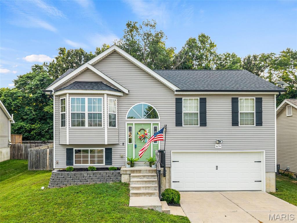 Move-In Ready in Stonewater! Welcome to 1679 Waters Edge Way in Pevely—an impeccably maintained split-foyer home offering 3 bedrooms, 2 full bathrooms, and 1,064 square feet of stylish, modern living.
Built 8 years ago, this home has been thoughtfully upgraded with a brand-new roof (2026), updated interior paint, new kitchen island, farmhouse sink, new stove/oven, painted interior doors, and updated light fixtures throughout. Every bedroom features overhead lighting and ceiling fans for added comfort.
From the moment you arrive, you’ll appreciate the home’s charming curb appeal with new front landscaping and a beautifully constructed retaining wall. Step inside and head upstairs to an inviting open-concept living room, dining area, and kitchen, where soaring vaulted ceilings, abundant natural light, and scratch-resistant engineered wood flooring create a bright and welcoming space. The updated kitchen is ideal for both everyday living and entertaining, with a center island, modern finishes, and seamless flow into the dining and living areas.
Sliding glass doors off the dining room lead to the deck overlooking the fully fenced, level backyard that backs to mature woods, providing exceptional privacy. The backyard also features raised garden beds, a parking pad with double gate access for a boat or outdoor toys, a small pool, and a storage shed that stays with the home.
The unfinished walkout lower level is ready for your personal touch, featuring a rough-in for a future full bathroom and ample space to finish into a family room, home office, additional bedroom, gym, or recreation area. The oversized two-car garage offers built-in storage, a workbench area, and a 220V outlet ready for your electric vehicle.
As an added bonus, the small pool, patio set, primary bedroom furniture AND the Whirlpool washer and dryer set are included! Located just steps from Stonewater’s private fishing lake and scenic walking trail, this home combines modern convenience with outdoor recreation. Clean, updated, and truly move-in ready—schedule your private showing today before it’s gone!