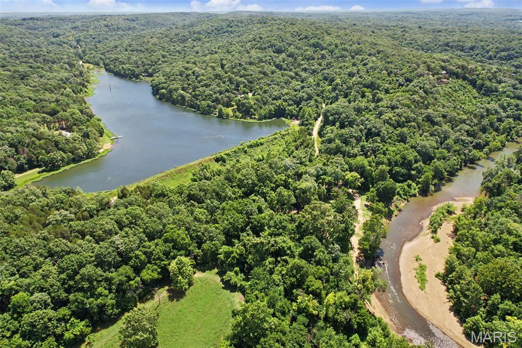 These 10.63± acres are in the Bid Woods community of De Soto, Missouri. This property features frontage on the community's largest lake, a 19± acre lake available for fishing, kayaking, canoeing, and other recreational activities. Big River community river access is located less than 1,000 feet from the property boundary along the private community roadway, providing convenient access for floating, fishing, and swimming. The property is equipped with a well, septic system, and concrete slab, making it ready for a new home, cabin, or shop. The acreage offers a mix of open and wooded ground with multiple possibilities for residential or recreational use. Located in the Sunrise School District with an annual HOA fee of $200, Big Woods provides private road maintenance and access to community amenities. Conveniently situated near De Soto while offering space for year-round living or a weekend property. Hunting, ATV/UTV, mobile and manufactured homes are permitted.
