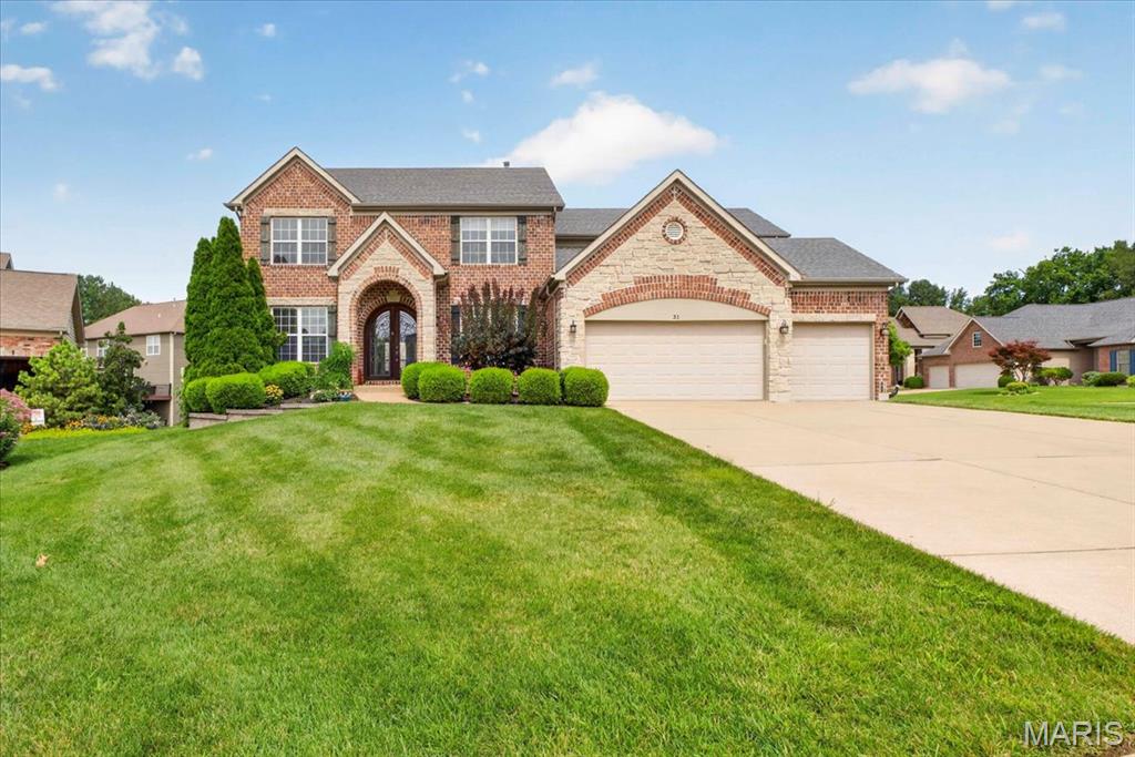 Experience refined living in this stunning brick and stone 4BR/4.5BA Two Story Home, perfectly situated on a beautifully landscaped cul-de-sac lot in an exclusive neighborhood of just 28 homes.  From the arched covered entry and custom wood front door to the three car garage and wrought iron fenced back yard, every detail reflects timeless elegance.  The Open Floor Plan is designed for both sophisticated entertaining and everyday comfort.  A private office with hardwood floors and a Formal Dining Room featuring wainscoting and a dramatic coffered ceiling with triple crown molding welcome you inside.  The impressive Great Room showcases hardwood flooring, triple crown molding, custom built-ins, a striking gas fireplace, and a five bay window overlooking the back yard.  At the heart of the home is a gourmet Kitchen appointed with 42” white custom cabinetry, granite countertops, stainless steel appliances, tile backsplash, a large Center Island, walk in pantry, and an adjoining Hearth Room.  The Breakfast Room opens to the deck, creating seamless indoor-outdoor living.  The luxurious Primary Suite offers a coffered ceiling, expansive walk-in closet, and a spa-inspired bath with dual vanities, jetted corner tub, glass block accents, tiled walk in shower, and private water closet with bidet.  Three additional bedrooms are thoughtfully designed with a Jack-and-Jill bath and an additional full bath.  The Finished Walkout Lower Level is an entertainer’s dream, featuring a custom walk-behind bar with wine fridge, Kegorator, dishwasher, and sink, plus a spacious Recreation Room with a second gas fireplace and large TV mount.  An additional Flex Room is ideal for a fitness studio, home office, or guest space.  Ideally located between Fiese Road and Highway K, you’ll enjoy convenient access to shopping, dining, and major highways while coming home to the privacy and prestige  of one of the areas most desirable communities.  This exceptional residence offer luxury, craftmanship, and an unparalleled lifestyle.