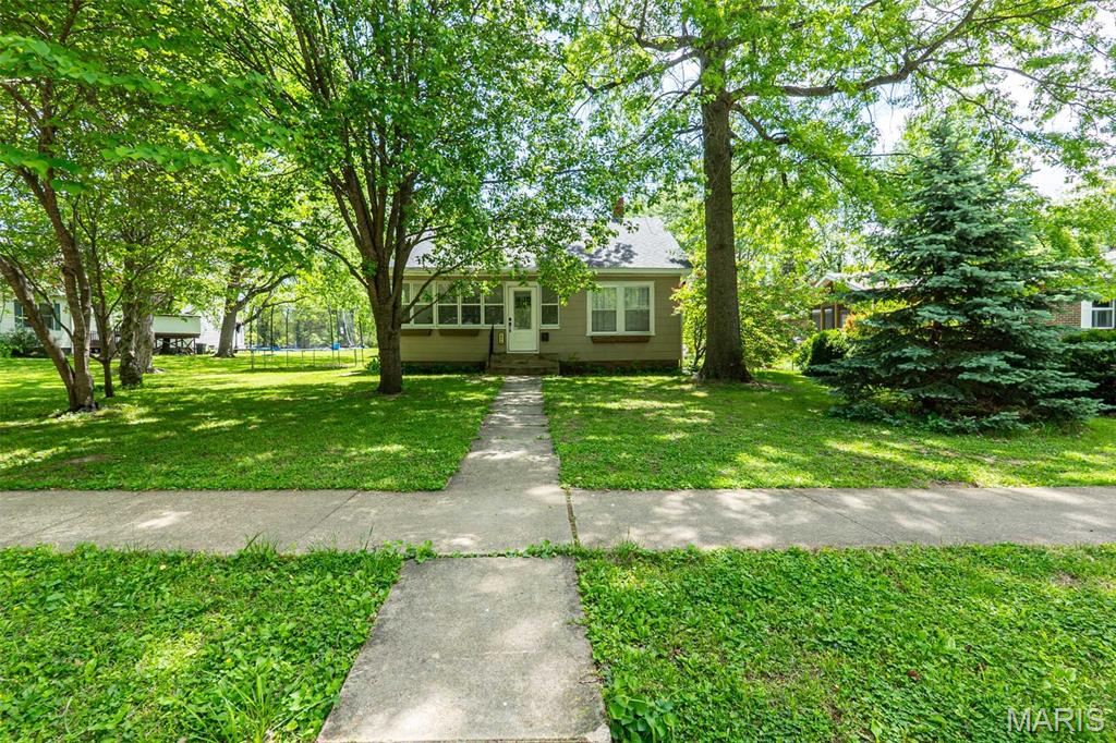 Charming bungalow in a prime location and nestled close to the park, pool, school, and library! This 3-bedroom, 1.5-bath home offers a cozy yet functional layout with a  welcoming gas fireplace and a bright sunroom--perfect for relaxing year-round. The kitchen features stainless steel appliances, and you'll love the clean, modern feel of no carpeting throughout. A detached garage adds extra storage and convenience. This home blends comfort, charm and location all in one!!