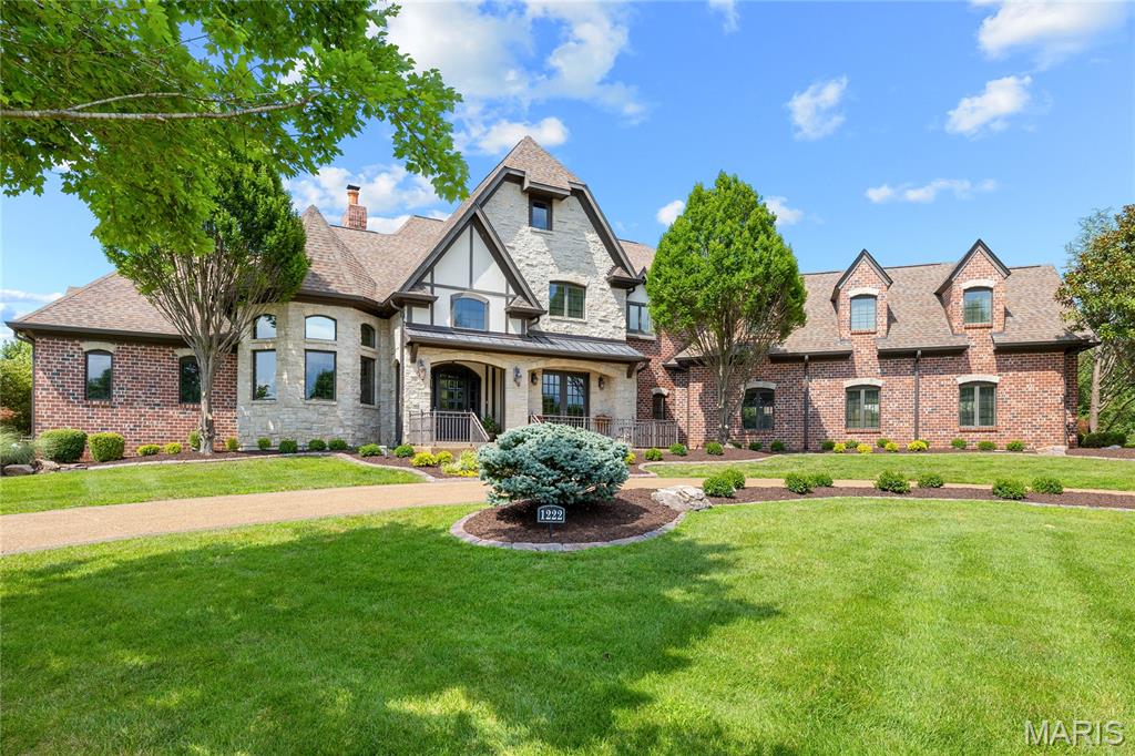 Situated within an exclusive gated enclave of custom-built homes, this extraordinary 7,214-square-foot full brick and stone estate by Elan Development masterfully blends timeless architecture with modern luxury. A striking arched mahogany front door welcomes you into a grand barrel-vaulted foyer, setting the tone for the exceptional craftsmanship found throughout. Freshly painted interiors and brand-new carpeting enhance the home's move-in-ready appeal. Just off the entry, a richly appointed paneled study with a 12-foot box-beam ceiling and French doors provides an elegant home office, while the formal dining room offers the perfect setting for memorable gatherings. The spectacular great room is filled with natural light from a dramatic wall of windows and showcases a stunning stone fireplace flanked by custom-built bookcases. Designed for both everyday living and entertaining, the gourmet kitchen is a chef's dream, featuring 42-inch custom cabinetry, granite countertops, commercial-grade appliances, and an impressive 9-foot center island. Adjacent to the kitchen, the bright breakfast room flows seamlessly into the expansive timber-beamed hearth room, where a dramatic floor-to-ceiling stone fireplace creates an inviting gathering space ideal for relaxing or entertaining on any scale. The luxurious primary suite serves as a private retreat, complete with two customized walk-in closets and a stunning marble spa bath featuring a soaking tub and premium finishes. A dual staircase leads to four additional spacious bedrooms, each offering its own ensuite bath for ultimate comfort and privacy. The finished lower level is designed for exceptional entertaining and relaxation, featuring a recreation room, game room, billiards area, gathering bar, wine cellar, fitness room, and a full bath. Atrium doors open to an extraordinary outdoor living oasis complete with a resort-style pool, cascading waterfall, expansive patio, and outdoor fireplace—creating the perfect setting for year-round enjoyment. Additional highlights include a circular driveway, a four-car garage, and exceptional attention to detail throughout this one-of-a-kind luxury residence.