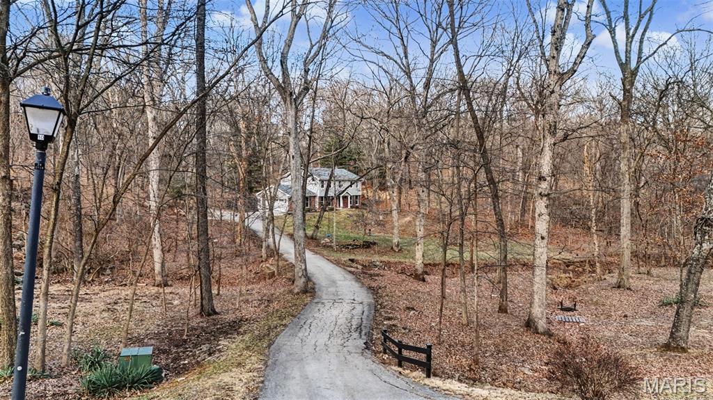 Tucked away on 3 serene wooded acres in Wildwood, this beautifully updated home offers the perfect blend of privacy, comfort, and modern living in the highly sought-after Rockwood School District. Fully remodeled in 2020, the home features an updated kitchen that opens seamlessly into the main living areas, creating a true open-concept layout ideal for everyday living and entertaining. Large windows throughout flood the home with abundant natural light and frame peaceful wooded views in every season. Front sitting room and separate dining give space for compartmentalization. All bedrooms are graciously sized. Primary bedroom comes with perks! Glamorous en suite, custom closet and even a fridge for coffee station to balcony! The finished basement provides flexible additional living space, perfect for a family room, home office as well as a gym. Enjoy the tranquility of country-style living with the convenience of nearby shopping and dining. This is a rare opportunity to own a move-in-ready home on acreage in one of West County’s most desirable locations!!!