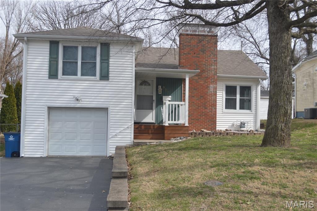 Bring your vision to this spacious three-bedroom, two-bath home offering approximately 1,764 square feet and plenty of opportunity to update, personalize, and build equity. The home features a welcoming living room with a brick fireplace, a separate dining area, generous bedrooms, an enclosed sunroom, and an attached one-car garage. The lower level provides additional storage, laundry, and workshop space. Outside, enjoy a large, level backyard with plenty of room for entertaining, gardening, or outdoor activities. With its solid layout and abundant potential, this property is ready for its next chapter. Property is being sold as-is.