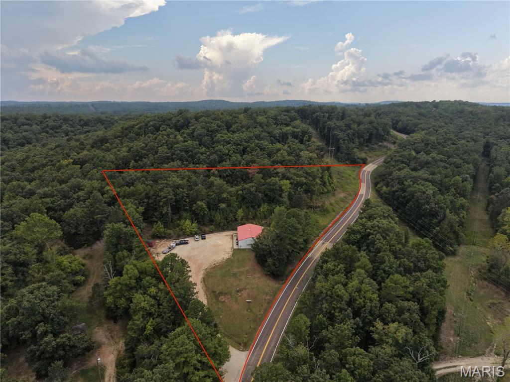 949 Highway M, Van Buren, MO - Commercial real estate offering on 3.92 +/- unrestricted acres strategically positioned along paved Route M, just 1 mile from US Highway 60 and minutes from downtown Van Buren, MO. The property features a versatile 3,200 sq. ft. multi-use commercial building currently operating as a active restaurant, fully equipped with installed public water and high-capacity electrical service. Restaurant equipment is available separately for a seamless, turn-key business handoff. With no restrictions of record and extensive paved highway frontage, the acreage offers limitless flexibility to expand or diversify—ideal for developing an RV park, nightly rental cabins, an outfitter shop, or self-storage units just to name a few. This prime location captures steady local trade along with a seasonal tourist stream drawn to the crystal-clear Current River, the world-famous Big Spring (flowing 286 million gallons daily), Mark Twain National Forest, and the 23,000-acre Peck Ranch Conservation Area, home to Missouri’s wild elk herd. Whether maintaining the existing hospitality operation, repurposing the structure, or developing the excess ground for additional income, this high-visibility Ozark commercial tract delivers operational freedom and growth potential.