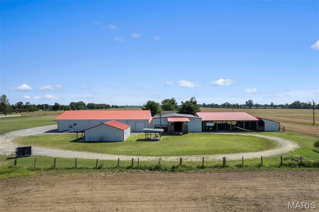 Welcome to this impressive rural property in the heart of Mississippi County's productive farmland.  Nestled along W. 416th Road just outside East Prairie.  This 4.6 acreage offers wide open spaces, functional outbuilding and a comfortable residential home with 900 sq ft open floor plan, utility room and full functioning kitchen, offering the classic Missouri Delta lifestyle.  This property is anchored by a cluster of substantial metal buildings featuring crisp white walls and distinctive red roofs.  These large barn shelters provide excellent covered spaces for equipment, have storage, livestock or workshop use.  Six horse stalls and tack room, roping barn and loafing barn make this ideal for farming, ranching and equestrian use.  Professional photography and drone imagery showcase the scale and potential of this ready to work property.

Duplicate listing:  MLS # 26058175