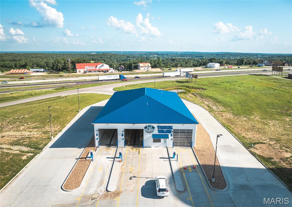 This 3.08 m/l acre property is located just off I-44 at Exit 189 in Rolla, Missouri, with access from Enterprise Drive. Positioned next to the newly developed QuikTrip Travel Center and near Love’s Travel Stop, McDonald’s, and Subway, this site benefits from strong visibility and steady traffic from both commercial drivers and everyday travelers. Located near the Hy Point Industrial Park, the property is well-positioned to serve local industry as well as interstate traffic. The site features a newly constructed, self-service truck wash totaling approximately 8,030 m/l square feet with three oversized bays. Built by the developer with quality in mind, the facility includes heated floors and an oil separator tank. A 20x20 m/l office with a bathroom, radiant floor heat, and window A/C provides a functional and comfortable on-site workspace. With its strategic location near major fuel stops, industrial operations, and I-44 access, this property is a prime opportunity for owner-operators or investors looking to tap into the consistent flow of highway and local traffic.