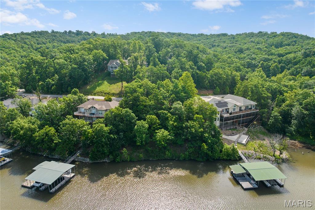 Discover this premier lakefront lot in the highly sought-after Cross Creek community, an exceptional park-like neighborhood just 4.2 miles off Hwy 54 on the outskirts of Camdenton. Nestled behind a secure gated entrance, this prime lot boasts 120 feet of pristine lakefront at the 31MM in Linn Creek Cove. Enjoy spectacular views and the ultimate peace of mind, framed beautifully by luxury homes already completed in the neighborhood. Cross Creek features top-tier amenities, including a zero-entry pool, playground, community docks with trailer parking, and brand-new asphalt roads winding entirely from the highway throughout the subdivision. Highly convenient to local schools, shopping, and only 15 minutes to Osage Beach; this location is ideal for a full-time residence or vacation getaway. Ready for your vision, the property offers hassle-free hookups to the community water and central sewer systems. Whether you are a builder or looking to construct your custom dream home, the seller is even willing to share their own architectural plans. Don't miss this rare opportunity for security, community excellence, and unparalleled lakefront living!