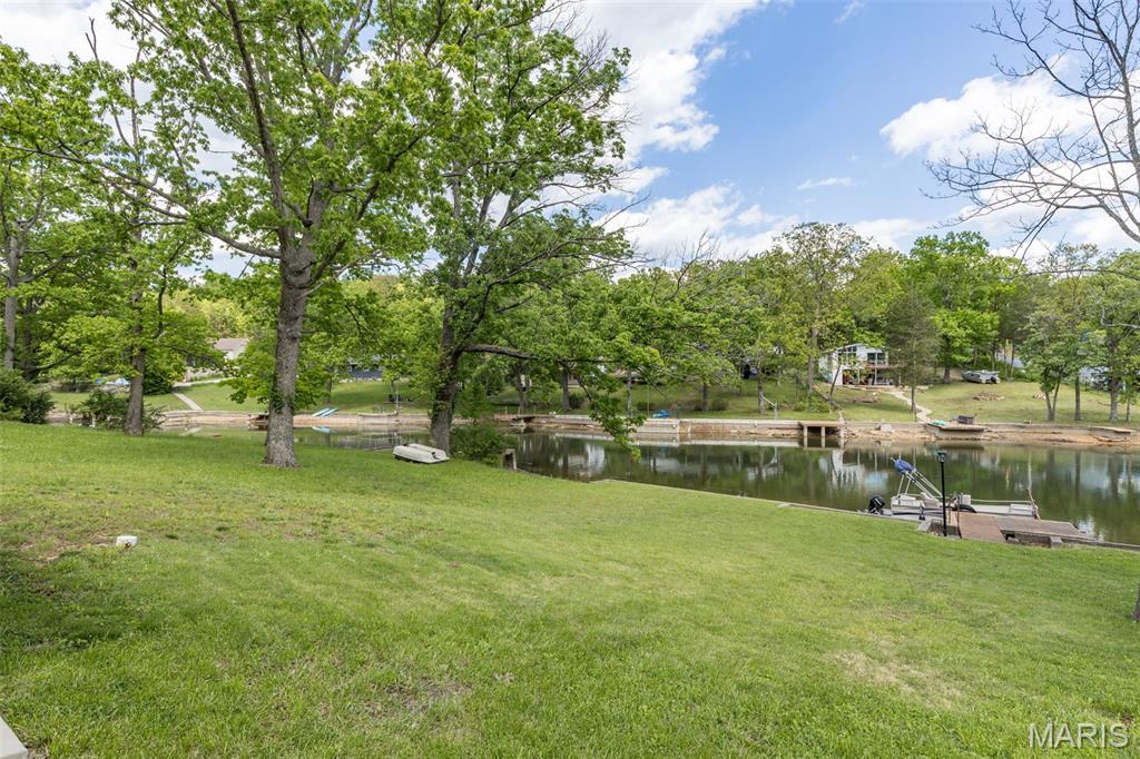 Lakefront Living at Its Best!
There’s something special about life at the lake. The slower mornings. The peaceful water views. The sound of boats drifting by while friends gather on the patio and dinner cooks on the grill. At this Lake Wauwanoka retreat, every day feels like a getaway while still offering the comfort and functionality of a well-cared-for home designed for real living.

From the moment you arrive, it’s easy to picture weekends filled with fishing, sunset cruises, bonfires, and long conversations under the stars. Tucked along the shoreline with a private dock and sweeping water views, this updated home blends indoor comfort with the outdoor lifestyle people dream about.

Inside, thoughtful updates make the home move-in ready while still leaving room to personalize and make it your own. The fully remodeled kitchen, completed in 2018, features quartz countertops, updated cabinetry, modern finishes, and a clean, efficient layout that flows naturally into the main living spaces. Luxury vinyl plank flooring runs throughout most of the home, creating a durable and cohesive look that fits perfectly with lake life.

The lakeview living room may quickly become your favorite spot in the house. And it can easily be converted into a 3rd bedroom! Large windows pull in natural light while framing peaceful water views that change beautifully throughout the day. Morning coffee feels different here. Evening storms rolling across the lake feel unforgettable. The flexible floor plan also offers options for changing needs, including the potential to convert the lakeview living area into a third bedroom. The dining space can easily transition into an additional gathering room centered around the fireplace, creating even more flexibility for entertaining or relaxing after a day on the water.

Step outside and the lifestyle truly comes to life. The oversized patio overlooking the lake was made for entertaining. Picture an outdoor kitchen, a large pergola strung with lights, Adirondack chairs gathered around a fire pit, and family and friends spending entire weekends outdoors because nobody wants to leave. Honestly, once people visit, you may have trouble getting them to go home!

The private dock offers direct access to the clean, well-maintained lake where boats up to 10HP are permitted, making it ideal for pontoons, fishing boats, kayaking, or simply floating the afternoon away. Whether you love fishing at sunrise, slow evening cruises, or spending summer days anchored with neighbors and friends, the lake becomes part of your everyday life here.

Beyond the property itself, Lake Wauwanoka offers an incredible recreational lifestyle with access to more than 700 acres of community amenities. Residents enjoy hiking trails, ATV and UTV riding areas, fishing ponds, wooded spaces to explore, designated hunting and fishing areas following local guidelines, a gun range, sandy beach area, playground, picnic spaces, beach volleyball court, and a clubhouse available for private gatherings and events. It’s the kind of place where weekends naturally turn into memories.

Additional major updates provide peace of mind, including a metal roof installed in 2018, a whole-house water filtration system, a 3-year-old water heater, and a brand-new driveway with a spacious 3-car parking pad perfect for vehicles, lake toys, ATVs, or guests. There’s even additional street parking, making hosting easy.

Whether you’re searching for a full-time residence, a weekend escape, or a place where life simply feels a little more relaxed, this property delivers the rare combination of updated interior spaces, outdoor recreation, and true waterfront living. Seller is also offering a home warranty, making this lake retreat ready to enjoy from day one.