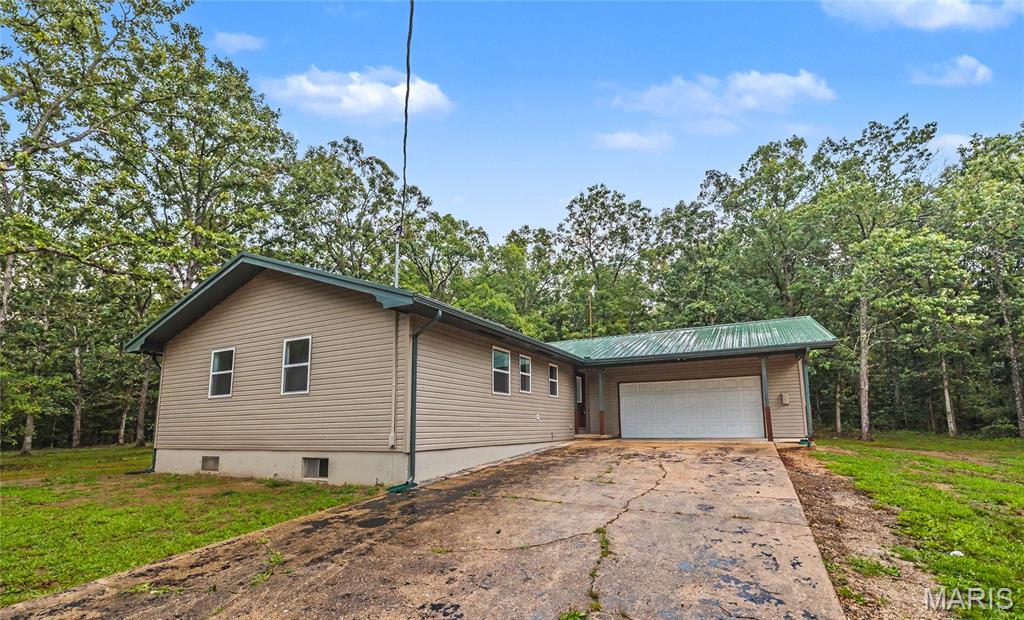Escape to your own private retreat! Conveniently located just 15 minutes from Rolla and 10 minutes from Salem, this beautifully remodeled home sits in the heart of 20 wooded acres, offering the perfect blend of privacy and convenience. A long, winding driveway leads you to this stunning 3-bedroom, 2-bath home that has been completely renovated from the ground up.

Inside, you'll find an open-concept floor plan featuring a spacious living room, a gorgeous new kitchen, and a main-level primary suite. Every detail has been updated, including new windows, siding, luxury vinyl plank flooring, a brand-new deck, and much more—making this home truly move-in ready.

The full unfinished walk-up basement provides endless possibilities for additional living space while also serving as the perfect storm shelter and storage area. Additional features include a durable metal roof, private well, and attached 2-car garage.

If you've been searching for a secluded property with modern updates and room to roam, this is it. Schedule your private showing today!