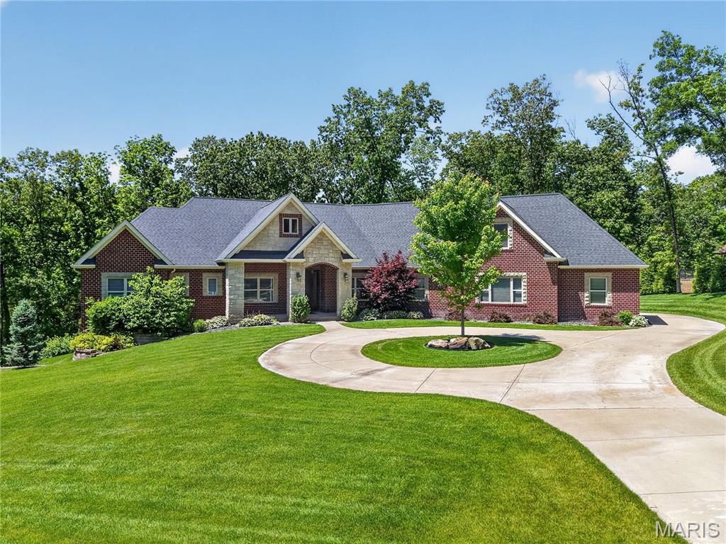 Impeccably maintained and nestled on 3 partially wooded acres, this stunning home is a true standout. Offering over 5,500 sq ft of finished living space, it is thoughtfully designed for multi-generational living and everyday comfort. Step inside to a welcoming foyer with a separate office just off the entry. The main level showcases seamlessly connected main living areas with great natural light, an 11’ coffered ceiling in the living room, bamboo flooring, and a wall of windows framing the peaceful, tree-lined setting. The beautifully appointed kitchen features custom cabinetry, quartz countertops, a large island with seating and storage, and a spacious walk-in pantry. The primary suite offers a tray ceiling and spa-like ensuite bath with freestanding tub, tiled shower, dual vanities, and generous walk-in closets. Two additional spacious main level bedrooms each feature their own private ensuite bathrooms, providing comfort and privacy for family or guests. A bonus room above the garage, complete with its own mini-split system for added comfort and efficiency, offers even more flexible living space. The impressive walkout lower level is equally well-appointed, featuring a second primary suite, dedicated office, additional bedroom, full kitchen with quartz countertops, a large walk-in pantry, and a spacious living area anchored by a wood-burning stove. Additional highlights include geothermal HVAC, a 4-car garage plus a tuck-under garage, water softener, sprinkler system, two 50-gallon water heaters, humidifier, buried propane tank, professionally tinted windows on the backside of the home and more. A rare combination of space, quality, and setting—this home is a must see!