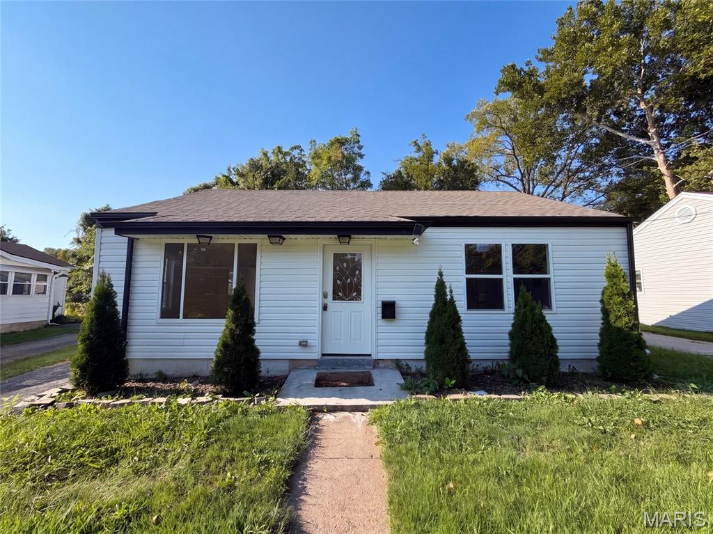 316 Lithia Ave is a single-story Saint Louis home set on a level lot. The kitchen features stainless steel appliances, a center island with a breakfast bar, and generous cabinetry that opens directly to the main living area for a connected floor plan. Large windows and a front entry fill the living space with natural light over wood-look flooring. The primary bedroom provides a comfortable space with additional bedrooms nearby, while the full bathrooms include a tub-and-shower combination and a separate walk-in shower finished with tile surrounds. A dedicated laundry area, a detached one-car garage, and a fully fenced backyard add everyday function. Neutral interior finishes complete this well-maintained residence with practical amenities throughout every room. Included 100-Day Home Warranty with buyer activation