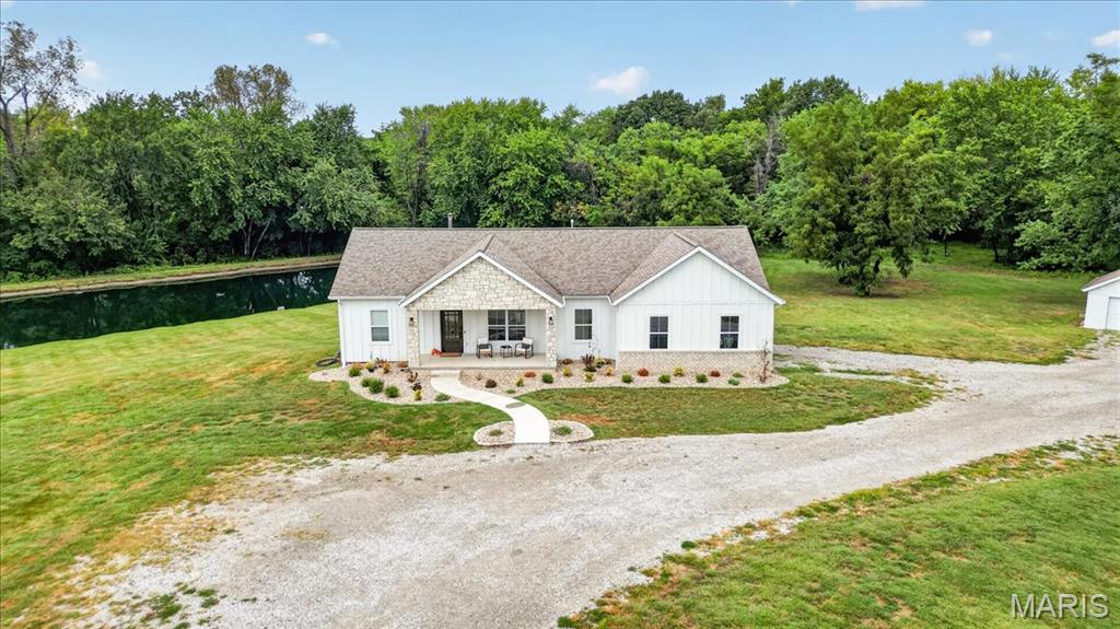 Completely reimagined in 2025, this exceptional 6-bedroom, 3-bath ranch combines refined interiors with the privacy and versatility of 5.21 acres. The open-concept layout centers around a custom kitchen featuring Taj Mahal quartzite countertops, an oversized island, stone backsplash, Sub-Zero refrigeration, microwave drawer, and double-drawer dishwasher. The main level offers three bedrooms and two full baths, including a private primary suite with outdoor access and a beautifully renovated bathroom featuring a tiled double shower, double vanity, pocket door, and generous closet. The walkout basement provides three additional bedrooms, a third full bath, a large entertaining area, ample storage, and direct outdoor access. The home has been re-sided with durable Hardie siding featuring board-and-batten and horizontal lap styling accented by stone and brick. Enjoy a picturesque pond with a fountain, aerators, and remote-controlled lighting, plus a detached garage and substantial 30x50 outbuilding with an oversized door. The furnace was replaced in 2025 and includes a Fresh-Aire UV APCO-X Ultra whole-home air-treatment system and an AprilAire whole-home humidifier. Additional improvements include a tankless water heater, water softener, approximately five-year-old roof, Gemstone exterior lighting, Alarm.com security system, city water, and a private well. From the sophisticated interior to the serene acreage and impressive amenities, this remarkable property is a true showstopper. More photos to be uploaded tomorrow Sept. 11th.