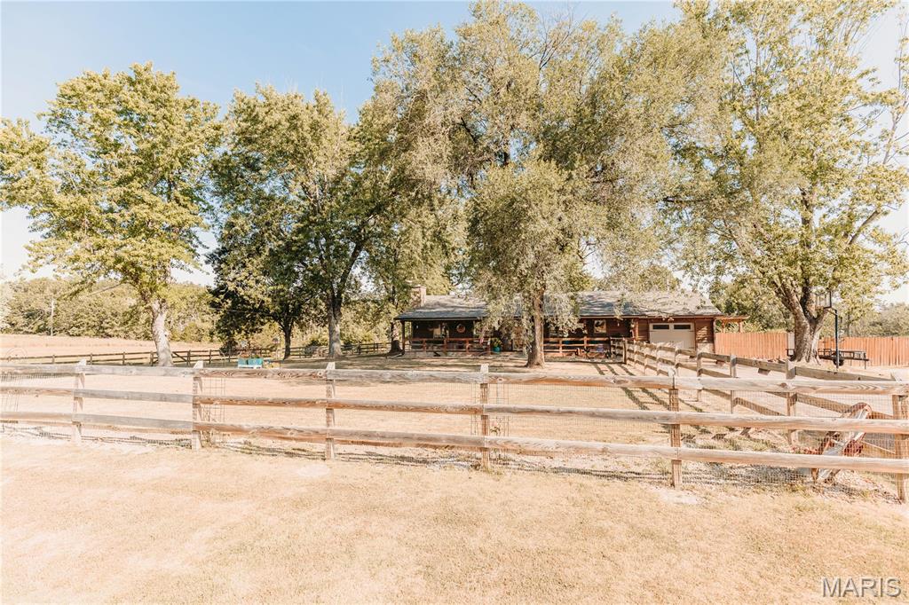 Farmhouse on 10+/- Acres in the Crocker Area! Enjoy a blend of country setting, usable acreage, and convenient access with this 3-bedroom, 2-bath farmhouse situated on 10+/- acres of both cleared and wooded land with highway frontage. The property offers open fields, a pond, and plenty of room for animals, outdoor activities, or simply enjoying the extra space. Inside, you'll find spacious rooms, wood flooring, beautiful woodwork, built-ins, and a stone-surround propane fireplace that adds warmth and character to the living space. The updated kitchen features newer countertops, backsplash, sink, garbage disposal, refrigerator, and select lighting. Additional improvements include a roof replaced approximately three years ago, a newer water heater, and an on-demand water heater serving the primary bathroom.  The washer and dryer are also included, adding another convenience for the new owner. Outside, the barn/shop with a second story provides excellent additional space with potential for a workshop, storage, office, hobby area, or other uses. With a combination of cleared acreage, wooded areas, fields, and a pond, this property offers plenty of possibilities for its next owner. Conveniently situated in the Crocker area and approximately 15 minutes from Waynesville, this property offers the space and setting of country living while keeping everyday conveniences within an easy drive. Come see all this property has to offer!