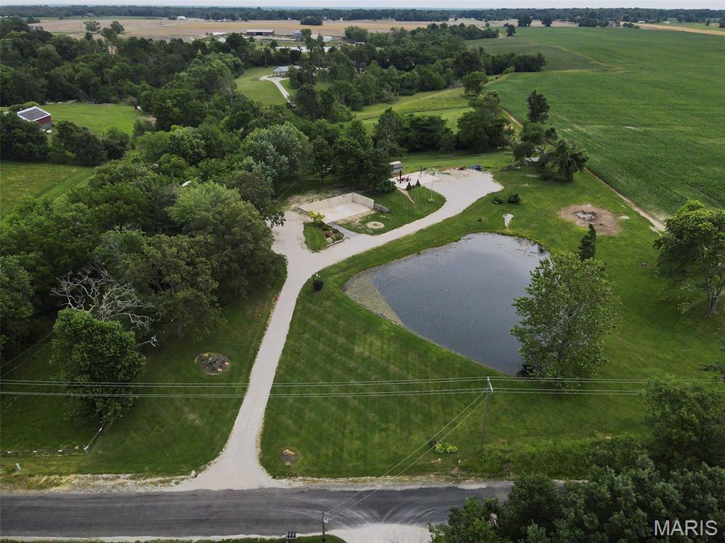 Beautiful 5 acre lot just outside of town in Bethalto School district with a private pond.  This lot previously had a home on it that was destroyed in a tornado, the poured concrete foundation with rough in plumbing is still in tact with no damage. There is also a large concrete pad where an outbuilding once stood that could be built on again. A smaller shed remains.  All utilities are still available at the property, just design your home to fit on the foundation and you can save a lot of money! This property has mature trees and some fencing and so much potential! Please contact listing agent with any questions.