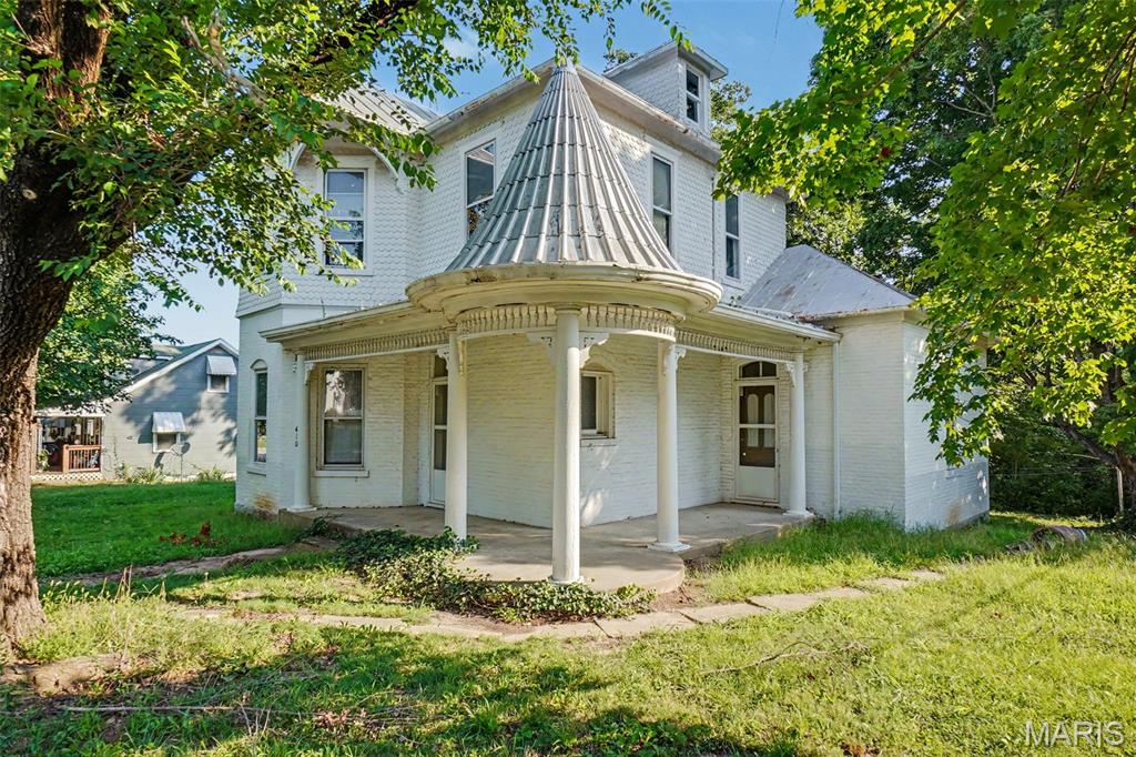 Motivated seller says "Bring all offers"!!!  A Rare Piece of New Haven History! Built in 1880, this distinctive historic residence offers a remarkable collection of architectural details and old-world craftsmanship rarely found in today's homes. From the moment you arrive, the ornate covered porch, unique exterior architecture, decorative siding, mature trees and original character set this property apart.

Inside, the craftsmanship continues with beautiful original woodwork, detailed trim, classic pocket doors, original doors and hardware, vintage light fixtures and one of the home's true showpieces—a stunning, intricately detailed staircase. The spacious living room features an Atlanta Stove Works wood-burning stove set against a brick hearth, creating a warm focal point with unmistakable historic charm. A formal dining room provides an elegant gathering space and connects naturally with the home's other main-level living areas.

The main floor includes a primary bedroom and full bathroom, while three additional bedrooms are located upstairs. The kitchen retains its vintage character and includes an electric cooktop and oven, dishwasher and refrigerator. Original wood flooring is believed to remain beneath portions of the existing carpet, offering an exciting opportunity for a future owner to uncover and restore additional historic character.

Modern improvements include new central heating and air conditioning and 200-amp electrical service, providing an important foundation for future improvements. The basement offers additional utility and storage space, along with a rough-in for a shower.

Outside, the property is surrounded by mature trees and established landscaping, with a detached historic outbuilding adding even more character and potential. The covered porch and distinctive architectural elements create an exceptional first impression and showcase the home's unique place in New Haven's history.

This property is being sold AS-IS and is subject to survey and subdivision of the lot.   It presents an exceptional opportunity for an owner, investor or preservation-minded buyer with the vision to restore and enhance a truly one-of-a-kind historic residence. Homes with this level of original architectural character rarely become available. Bring your vision and make this remarkable 1880 residence part of New Haven's future while preserving a piece of its past.