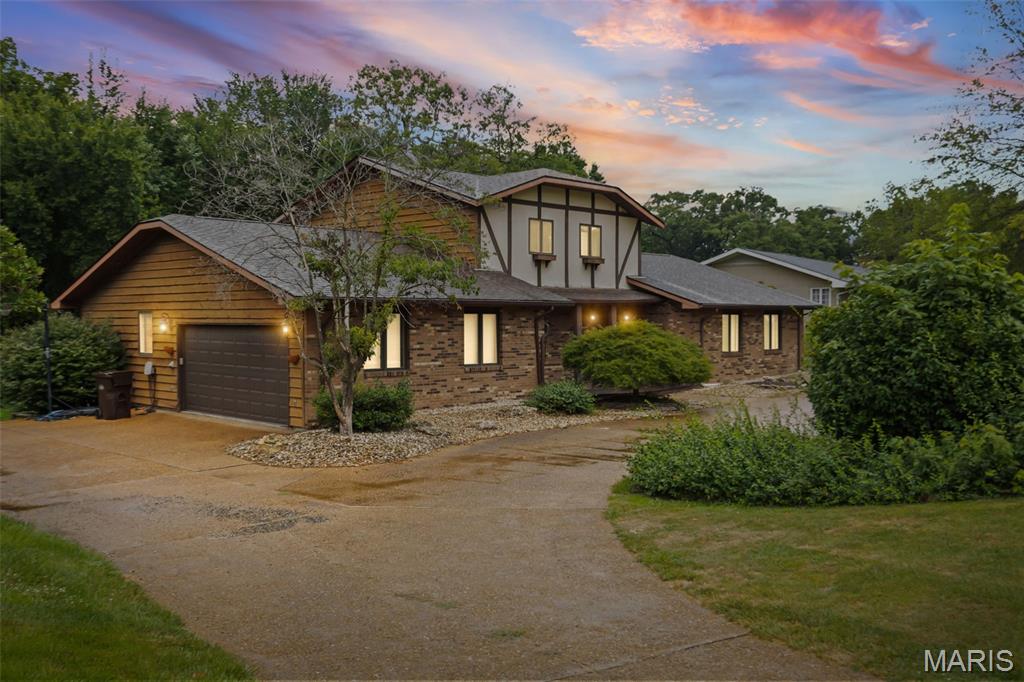 Welcome home to this custom Tudor-inspired beauty nestled on a spacious 0.58 acre lot in one of the area’s most desirable locations! Offering an impressive 2,856 square feet, this home combines timeless character with modern updates and the space today’s buyers are looking for. Step inside to discover a thoughtfully designed floor plan featuring 3 bedrooms, and 3 bathrooms along with a bonus room in the lower level. The main-floor primary suite is a true retreat, complete with a custom-built closet system in the 13’ x 6’ walk-in closet. The primary suite also features new flooring installed in February 2026. Convenient main-floor laundry makes everyday living a breeze. The heart of the home is the expansive kitchen and dining area, offering plenty of cabinetry with room for gathering and entertaining. You’ll appreciate the updated kitchen featuring newer appliances (September 2025), beautiful new counter-tops, and a stylish back-splash, creating a fresh and modern space. Just beyond, the inviting family room showcases a stunning stone fireplace, perfect for cozy evenings at home. Step outside to the wonderful screened-in back deck with new outdoor carpet, where you can relax while overlooking the large backyard. The full walkout basement offers endless possibilities for additional living space, a bonus room, a recreation area, a home gym, and/or extra storage. This home has been extensively updated, including brand-new roof and gutters, new upstairs flooring installed in 2025, and numerous additional improvements throughout, giving buyers peace of mind for years to come. Complete with an attached two-car garage, abundant storage, exceptional living space, and a prime location on a large lot, this home truly checks all the boxes. Homes like this don’t come along often. Schedule your private showing today before this incredible property is gone!