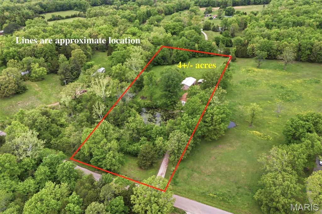 Rare find south of Potosi! This unrestricted 4-acre property offers the ultimate blend of functional living and outdoor serenity. The 2-bedroom, 1-bath home features an expansive sunroom off the living area, providing year-round views of your private, spring-fed pond. Whether you're watching the sunrise or the local wildlife, this space is the heart of the home. The acreage is a mix of natural beauty and utility, featuring a small stream meandering through the corner and approximately 0.75 acres of level, open field—perfect for a large garden, small livestock, or future expansion. Hobbyists and mechanics will be impressed by the oversized 30'x55' 2-car detached garage. This shop is fully insulated with durable metal walls and ceilings, and even includes its own on-site bathroom for added convenience.2 car carport.  With no restrictions, you have the freedom to truly make this property your own. Don't miss this opportunity for unrestricted country living with water features and a premium workshop!