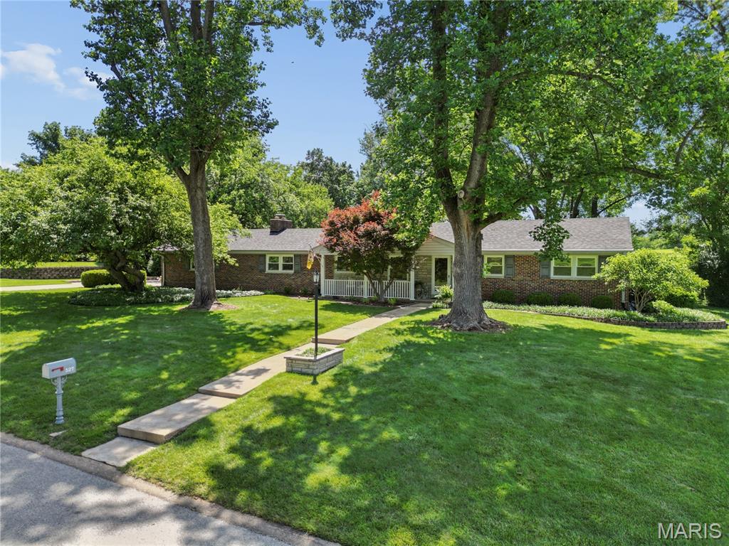 Stylish updates and classic Mid-Century Modern architecture come together beautifully in this exceptional ranch home. Nestled on a lush, wooded 0.68-acre lot backing to Creve Coeur Golf Course, the home offers a peaceful setting with magnificent views. From its timeless all-brick exterior and inviting covered porch to the charming entry, every detail welcomes you in. Abundant windows throughout fill the home with natural light. The expansive gourmet kitchen is a chef’s dream, featuring custom cabinetry, granite countertops, gas cooktop, double wall oven, built-in refrigerator, large center island with breakfast bar seating, and more. The breakfast room includes an elegant dry-bar pass-through for easy entertaining and an atrium door that opens to the patio. The versatile dining room—also ideal as a living room—features a wall of atrium doors, including french doors that lead to the covered patio, creating a seamless connection between indoor and outdoor living. Whether you're enjoying a quiet morning coffee or hosting friends and family, this inviting space is perfect for both relaxation and entertaining. The spacious family room offers a cozy wood-burning fireplace and an additional atrium door to the backyard. The primary suite is a peaceful retreat, complete with a generous sleeping area, two step-in closets, and a beautifully updated bath. Two additional bedrooms and a large updated hall bath complete the main level. The fabulous lower level provides added living space with a large recreation area, spacious office, full bath, laundry area with sink (newer washer and dryer included), and abundant storage. The home's flexible layout also offers the potential for main-floor laundry.  Combining flexibility, functionality, and timeless style, this home is designed for comfortable everyday living as well as effortless entertaining. It offers exceptional indoor and outdoor spaces in a truly special setting. Don’t miss your opportunity to own this exceptional home.