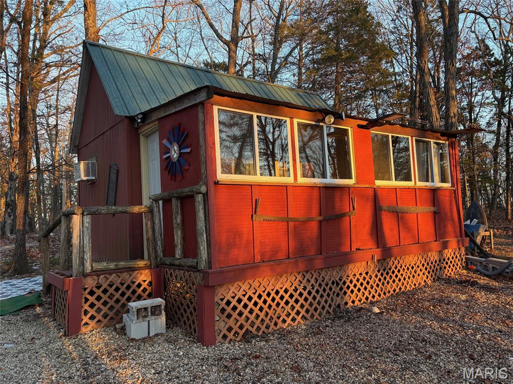 Pinnacle Lake!! Small rustic cabin nestled on nearly 5 wooded acres. The property lays level to rolling and features tons of mature trees. The cabin features electric, heat, & a/c . Front porch was recently enclosed for extra space and has a makeshift bathroom. Would make a great weekend retreat or an excellent new build homesite. Enjoy the 130 acre community lake that boasts excellent swimming, boating and fishing. There are also miles of community roads to cruise your SXS on and get to know the neighbors. Pinnacle Lake is a private, gated community less than an hour from Mid Rivers Mall. Making this a great alternative to some of the larger lake getaways.