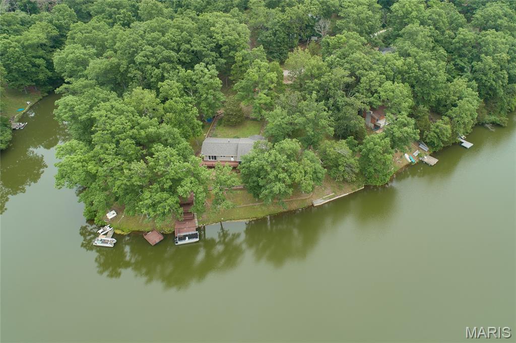 Back on the Market - NO Fault of Sellers. Escape to your own peaceful lakeside cabin! This absolutely stunning, turnkey Home or Weekend getaway sits on a quiet, spring-fed lake, offering the perfect blend of rustic charm and modern comfort. Whether you want a cozy permanent home or an unforgettable weekend retreat, this rare gem is completely updated and ready for you to move right in. Warm & Inviting Living Spaces - Step into the breathtaking great room, where soaring vaulted ceilings and a crackling wood-burning fireplace create the ultimate cozy atmosphere. Large windows frame beautiful views of the water, making it the perfect spot to curl up with a good book while watching the lake. The Heart of the Home - The completely remodeled kitchen blends modern convenience with a warm, welcoming vibe. It features stainless steel appliances and a gas (propane) stove, perfect for cooking hearty meals. The attached breakfast room walks straight out onto an expansive deck, making it easy to host family dinners or grill out by the water. Restful Retreats - This home offers two comfortable bedrooms and two fully updated bathrooms. The spacious primary suite serves as your private haven, with plenty of room for oversized, rustic furniture and a beautifully renovated en-suite bathroom.
Ultimate Lakeside Relaxation - Outdoor living here is pure bliss. Spend peaceful evenings listening to the crickets on the large screened-in porch, completely protected from the elements. Follow a series of beautiful wooden decks that wind down to the water's edge, offering multiple spots to fish, swim, or watch the sunset. Stress-Free Maintenance - Spend your time relaxing by the water, not doing chores. This home is built for easy living with several major updates already done for you with a Newer Roof, HVAC and Low maintenance Vinyl Siding! Properties on quiet, spring-fed lakes are incredibly hard to find. Don't miss your chance to own this slice of lakeside paradise—come see it today!