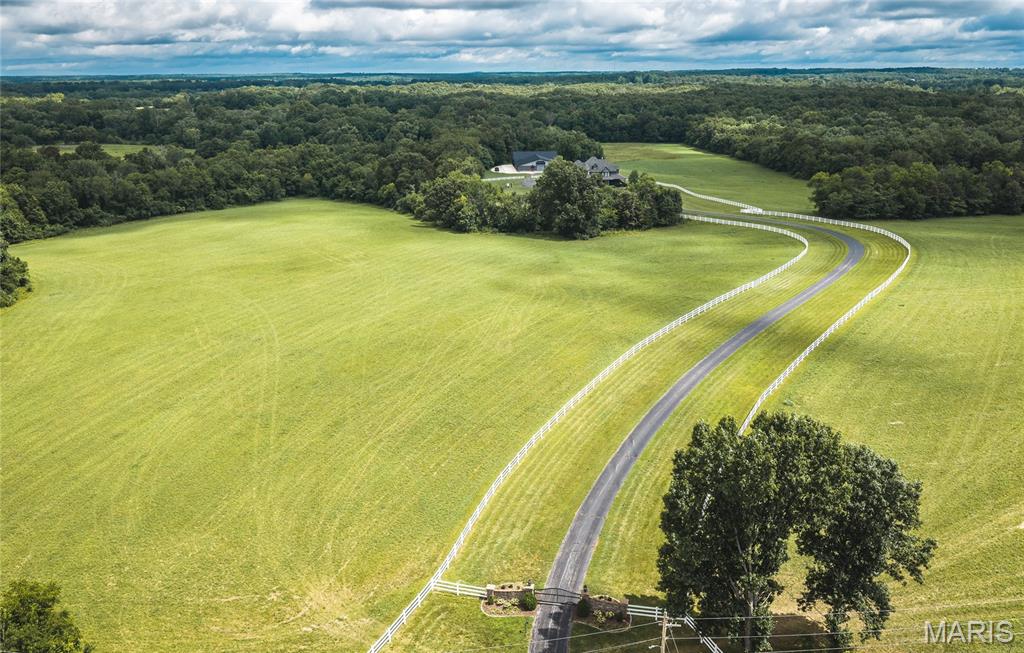 Experience the perfect blend of luxury, privacy, and outdoor recreation with this exceptional 50 +/- acre Ozark estate. The beautifully crafted home offers over 4,000 square feet of thoughtfully designed living space and features energy-efficient geothermal heating and cooling for year-round comfort. The property showcases an ideal mix of open pasture and mature timber, creating outstanding habitat for deer and turkey while providing plenty of room to enjoy the outdoors. Spend warm summer days relaxing by the in-ground swimming pool and unwind each evening with breathtaking Ozark sunsets from the screened-in porch. A gated, paved driveway leads you off the main road to a private setting accented by attractive vinyl fencing. Those needing exceptional storage or workspace will appreciate the impressive outbuildings, including a new 80x80 temperature-controlled building connected to an existing 80x70 machine shed—ideal for equipment, vehicles, hobbies, or even a home business. Outdoor enthusiasts will love the location, just minutes from Shawnee Mac Lakes Conservation Area for excellent fishing and a short drive to Indian Trail Conservation Area for hunting, hiking, and other outdoor recreation. Bring your kayaks and canoes and enjoy easy access to the Current River, renowned for floating, jet boating, smallmouth, largemouth, and trout fishing. You're also within easy reach of several of the Ozarks' most beautiful spring-fed streams, including the Upper Meramec River, Huzzah Creek, Big Piney River. So bring your fly rods.  The area just South of town is known for endless equestrian trails and horseback trail riding so Spring Creek offers opportunity to have your equestrian estate or raise your own beef.  Additional acreage available, up to 300 +/-  acres if you choose to add additional acreage. Call for pricing.  Montauk State Park is home to one of Missouri's premier trout fisheries, while millions of acres of Mark Twain National Forest provide outstanding public hunting opportunities. Dent County is renowned for exceptional turkey hunting, with impressive gobblers, as well as excellent Missouri whitetail deer hunting for both archery and rifle seasons. Golf enthusiasts will appreciate having Spring Creek Golf Course just across the road, making it easy to hop in your golf cart and head to the first tee. Properties of this caliber rarely become available. The Missouri Ozarks offers a welcoming rural lifestyle, low property taxes, and endless opportunities to enjoy the outdoors while remaining conveniently close to town. This executive-style home has been meticulously maintained and is truly move-in ready. Whether you're searching for a luxury country home, a premier hunting retreat, a working farm, or a family estate, this remarkable property offers the space, amenities, and location to experience the very best of the Missouri Ozarks.