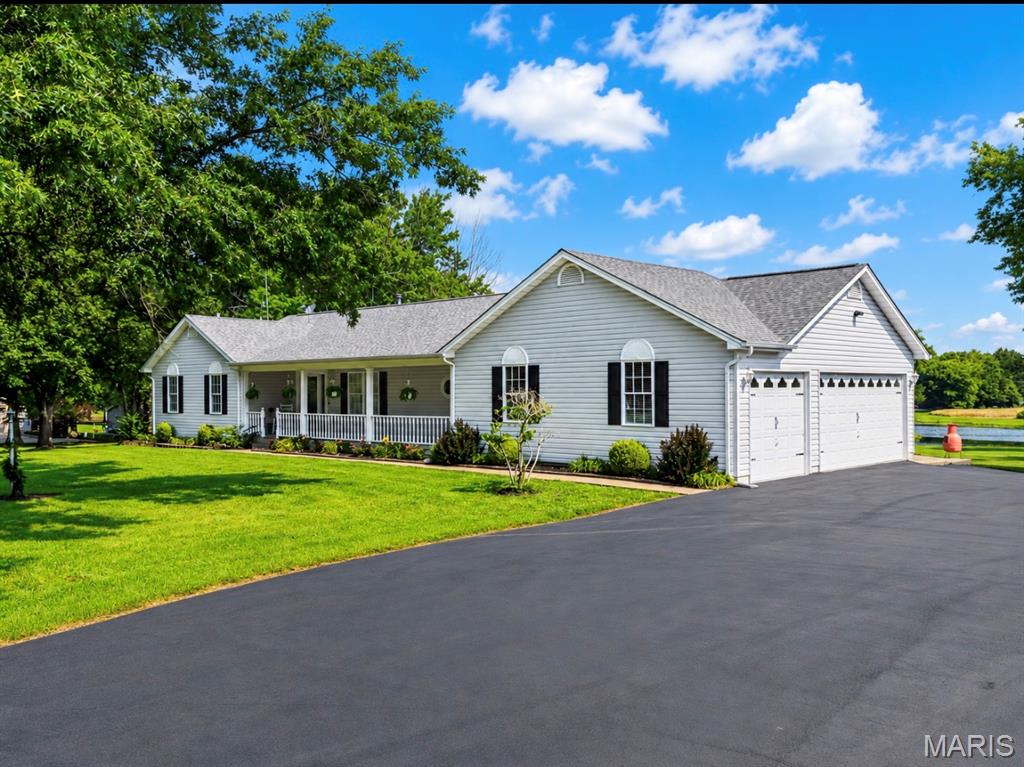 Luxury country living meets everyday convenience on this exceptional 10 unrestricted acre estate! Perfectly situated just minutes from Highway 40/61, Highway N, Winghaven shopping, New Melle, Augusta, and Defiance, you’ll enjoy the peace and privacy of country living while remaining close to award-winning wineries, restaurants, shopping, and an easy commute.
Beautifully updated and meticulously maintained, this impressive 4-bedroom, 3 full and 2 half bath home offers timeless elegance, quality craftsmanship, and incredible indoor and outdoor living spaces.
The welcoming entry foyer opens into the stunning vaulted great room where soaring ceilings, a striking exposed wood beam, two ceiling fans, a beautiful wood-burning fireplace, elegant planter shelf, and expansive windows create a warm yet sophisticated gathering space. The formal dining room offers flexibility for elegant entertaining or can easily serve as a refined home office.
The heart of the home is the beautifully remodeled kitchen, thoughtfully designed for both entertaining and everyday living. It features rich custom cabinetry, gorgeous granite countertops, a propane cooktop, double wall ovens, built-in microwave, refrigerator, double sink, tray ceiling with recessed lighting, and a spacious peninsula with breakfast bar. The adjoining breakfast room features a beautiful bay window and opens directly onto the covered deck, creating seamless indoor and outdoor living.
The spacious primary suite is a true retreat, complete with a bay window, charming window seat, and a luxurious spa-inspired bath offering double vanities, a jetted soaking tub, and separate shower. Two additional generously sized bedrooms complete the main level, including one with private bath access. A convenient powder room and spacious main-floor laundry room are located just off the oversized three-car side-entry garage, featuring an attractive epoxy-coated floor.
The finished walkout lower level offers exceptional flexibility with a massive recreation room, an open fourth bedroom, an additional half bath, and walkout access to the patio—perfect for entertaining, guests, hobbies, or multi-generational living.
Step outside and experience your own private retreat. The covered deck, complete with ceiling fans, overlooks a breathtaking stocked lake featuring a picturesque walking bridge leading to a private island. Spend evenings fishing for bass, catfish, crappie, bluegill, and grass carp, entertain family and friends, or simply relax while enjoying spectacular sunsets and peaceful surroundings.
The park-like grounds are beautifully landscaped and enhanced by a freshly paved driveway and an impressive 40’ x 60’ outbuilding with concrete floors, electric, and an attached 14’ x 60’ lean-to. Approximately six acres are currently leased to a local farmer, offering agricultural use and additional income potential.
Additional highlights include newer luxury vinyl plank flooring throughout the kitchen, breakfast room, and laundry room, a roof that’s only two years old, and countless updates reflecting exceptional pride of ownership.
This is more than a home—it’s a lifestyle. Enjoy peaceful mornings overlooking your private lake, afternoons exploring the nearby wineries of Augusta, Defiance, and New Melle, and evenings relaxing on your covered deck—all while being just minutes from major highways, shopping, dining, and modern conveniences.