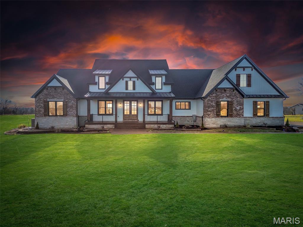 This stunning home is now on the market! Nestled on over 3 acres in Josephville, MO (Ft Zumwalt Schools), this brand-new property features 4 bedrooms, 3.5 baths, and over 4,100 sq ft of living space—nearly 3,000 sq ft on the main level. From the moment you step inside, you'll notice the attention to detail, with soaring 12' ceilings and a beautiful stone fireplace. The kitchen and walk-through pantry are sure to impress. The spacious master bedroom showcases a trayed Crawford ceiling, and the luxurious bathroom is simply breathtaking. On the main floor, there are two additional bedrooms, each with ensuite baths and walk-in closets. Even the laundry room exudes elegance. The finished lower level offers a 4th bedroom, another full bath, a large entertaining area, and ample unfinished storage space. Enjoy relaxing evenings on the covered front porch or back patio, both featuring stamped concrete. The oversized, insulated, and finished 3-car garage (28'x33') provides plenty of room for all your needs!
