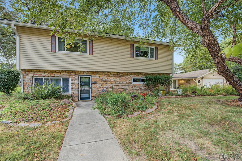 Welcome to this spacious and beautifully maintained split-level home situated on a generous corner lot in the heart of Edwardsville! Offering over 2,500 square feet of living space, this 4+ bedroom, 3-bath home combines timeless character with thoughtful updates and an unbeatable location near Dunlap Lake.
Step inside and you'll immediately appreciate the brilliance of natural light that fills the home. The spacious living room is anchored by a stunning floor-to-ceiling stone fireplace, serving as a striking architectural centerpiece that beautifully divides the living and dining rooms while creating warmth and character throughout the main living area.
The EAT IN kitchen offers stainless steel appliances, an abundance of cabinetry, and plenty of workspace for preparing meals, entertaining guests, or everyday living. Just off the sunroom in the front of the home, the inviting patio provides the perfect spot for morning coffee, colorful planters, or relaxing on cool summer evenings while enjoying the peaceful surroundings and sounds of nature.
The lower level showcases beautiful mosaic-patterned HEATED slate tile flooring throughout, adding style and durability to the additional living space. With four generously sized bedrooms with an available bonus room, there's flexibility for family, guests, a home office, or hobby space.
Outside, the freshly power washed home and lovely flowers are visually enticing. The oversized attached garage offers ample room for vehicles, storage, and workspace. The nearly HALF ACRE corner lot provides plenty of outdoor space to enjoy while being just moments from Dunlap Lake, where residents can enjoy beautiful views, lovely walks and a reconnect with nature. Located within the highly sought-after Edwardsville School District and just minutes from parks, shopping, dining, and major interstates, this home offers the perfect balance of convenience and lifestyle.
Home features a whole house air purifier. Seller has conducted pre inspections (mid August 2026) and is happy to share, saving the Buyer $$$. Annual termite treatment/plan is already in place. Radon and sewer reports will provide peace of mind. Don't miss this exceptional opportunity to own a spacious home in one of Edwardsville's most desirable locations. Schedule your private showing today!