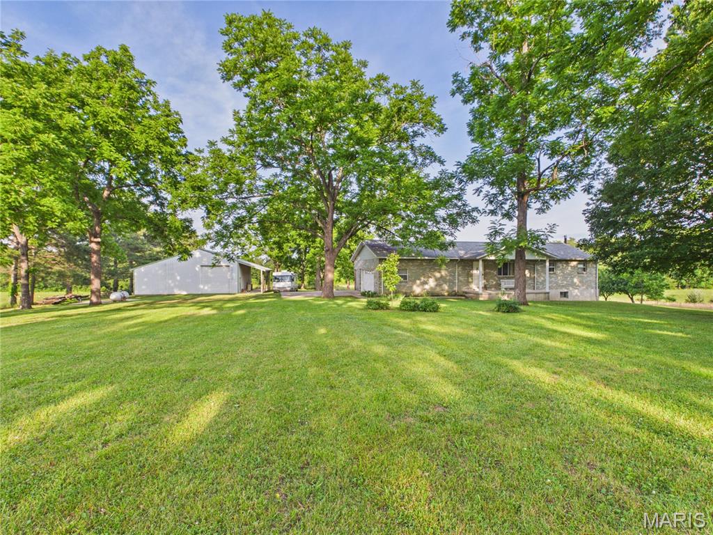Ultimate country living with endless potential! Escape to the peace and quiet of the countryside with this remarkable 39.50 acre Missouri property, offering the perfect blend of open pasture, mature trees, and room to breathe. Whether you dream of establishing a hobby farm, raising cattle, or bringing your horses home, this gently rolling acreage is fully cross fenced with barbed wire and ready for your vision.
Set well back from the county road down the tree lined driveway, the solid 1988 brick and vinyl sided ranch home sits framed by scattered shade trees. Featuring a 1,572 sq. ft. layout on the main level plus a partially finished walk out basement, the size, structure, and flow are absolutely ideal for a modern farmhouse renovation. Bring your design ideas and updates to transform this 4-bedroom, 3-bathroom home (featuring a main-floor sunroom and a lower level great room) into your custom dream estate!
A standout feature of the property is the massive 40x42 detached metal shop building, complete with a lean-to running the entire length of the structure. The perfect setup for heavy equipment, a tractor, boat storage, or a dedicated workshop. Enjoy unmatched privacy and beautiful rural views as the property adjoins wooded areas and government land. Complete with an on site generator, private well, septic system, architectural shingle roof, and located within the Twin Rivers R-X school district. Properties with this size, structure, and acreage don't come along often.