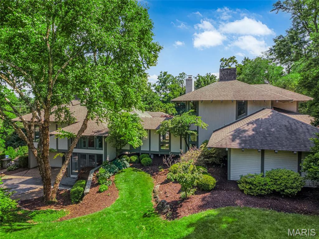 Architectural Masterpiece on Nearly 2 Acres in Chesterfield. Welcome to this one-of-a-kind Burton Duenke–designed estate, where sophisticated architecture & modern luxury blend seamlessly over nearly 2 private acres. Extensively maintained, this home showcases dramatic design elements, including a striking two-story glass entry and beamed ceilings that set the tone for what’s inside. A stunning art gallery hallway separates the private bedroom wing from the main living spaces. The primary suite is a true retreat, complete with a cozy fireplace, French doors opening to the pool, and a spectacular 23’ x 11’ spa-inspired bathroom with separate limestone vanities, abundant custom cabinetry, and a custom closet. Upstairs, a spacious bedroom suite offers a private balcony with panoramic views of the pool and landscaped grounds. The heart of the home is a chef’s dream: a gourmet kitchen with an 8.6’ x 6.6’ granite island, premium custom cabinetry, and top-tier appliances. Adjacent, the hearth room invites connection and comfort — ideal for everyday living and entertaining. Step outside to a resort-style backyard featuring multiple entertaining areas, a covered patio, and a completely renovated 20’ x 40’ gunite pool. A built-in shed with garage door provides functional storage for tools, yard equipment, and pool supplies. This extraordinary property offers privacy, style, and unparalleled architecture in one of Chesterfield’s most desirable locations.