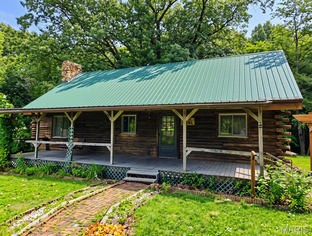 True country living on 6.34 acres in Litchfield schools. This is an authentic log cabin in a quiet, peaceful setting—you can't even see the house from the road, so privacy comes standard. The full covered front porch is the kind of spot you'll actually use—morning coffee, evening sunsets, all of it. Walk in to a spacious kitchen that opens up to the dining area and a large living room. Off the kitchen you'll find the full bath and the main bedroom. It was originally two bedrooms and still has two doors and two closets, so there's flexibility if you want to put the wall back. Upstairs is a loft-style bedroom with a large closet. The basement is full and unfinished—plenty of room for storage, a shop, or whatever you have in mind. Detached 2-car garage and an old horse barn round it out. Well water means you're close to off-grid out here. If you've been looking for space, quiet, and a home with real character - this is it.