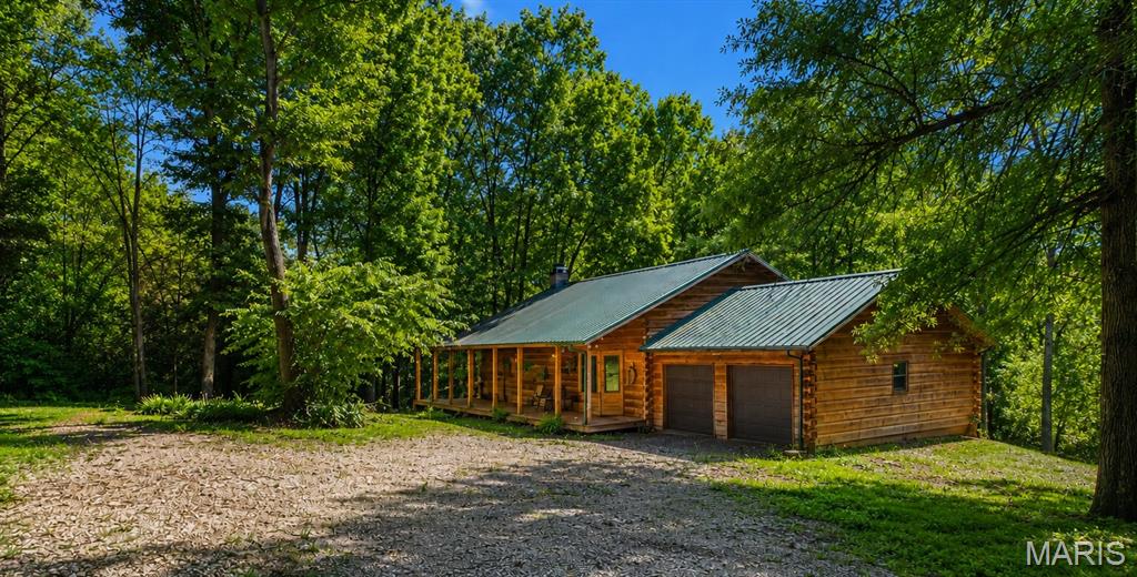 Escape to your own private retreat on 2.68 wooded acres in the highly sought-after Triad School District! This beautifully maintained log cabin offers the perfect blend of rustic charm and modern comfort. Featuring 1 bedroom, 2 full bathrooms, a walkout basement, and two additional sleeper rooms in the lower level, this home offers flexible living space to fit a variety of needs.

The heart of the home is the well-cared-for log cabin, showcasing beautiful tobacco wood flooring, warm wood finishes, a soaring stone fireplace, timeless craftsmanship, a storage loft, and the convenience of main-level laundry. Step outside onto the expansive half-wrap covered porch, where you can enjoy your morning coffee, unwind after a long day, and take in the peaceful surroundings. The property is accented by towering mature trees that provide exceptional shade, privacy, and a true park-like setting, while the backyard backs to a picturesque creek, creating a tranquil escape right outside your door.

The walkout basement also features a full bathroom and two additional sleeper rooms, providing even more versatile living space. A 2-car attached garage, durable metal roof, and the incredible natural beauty surrounding the home complete this one-of-a-kind property.

Whether you're looking for a full-time residence, a weekend retreat, or simply a place to escape the hustle and bustle, this property offers the serenity of country living while remaining just minutes from Troy, Edwardsville, O'Fallon, Scott Air Force Base, and downtown St. Louis.

Authentic log cabin craftsmanship, tobacco wood flooring, a welcoming half-wrap porch, mature, wooded acreage, and a beautiful creek-side setting make 2601 Staunton Road a rare opportunity you won't want to miss.