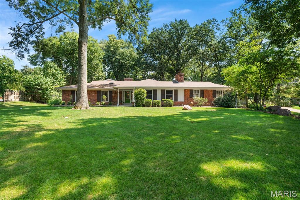 Open House Canceled- Under Contract, sight unseen-
Welcome to an exceptional sprawling brick ranch, perfectly situated on a gorgeous park-like one-acre lot in desirable Windsor Forest in Kirkwood. Surrounded by mature trees and nature, this special property offers the space, privacy and setting that are increasingly hard to find. Inside, more than 3,300 square feet of sun-filled main-floor living space flows beautifully for both everyday living and entertaining. The open-concept kitchen and family room create the heart of the home, while the inviting living and dining rooms are ready to host everything from intimate dinners to holiday gatherings. A vaulted sunroom brings the outdoors in with beautiful views of the expansive backyard. The impressive primary bedroom retreat, added in 1998, is truly a showstopper with soaring 17-foot ceilings, a dramatic floor-to-ceiling stone fireplace and walls of windows overlooking the picturesque grounds. An additional bedroom suite, 3rd bedroom and full bath finish off the main level. 3 gas fireplaces, a mudroom (main-floor laundry), a side-entry garage, irrigation system, newer systems, a home generator, and additional living space in the lower level, this home offers comfort, character, and incredible possibilities. A rare opportunity to enjoy one-acre living in the heart of Kirkwood — a beautiful home, an extraordinary setting and room to make it your own.