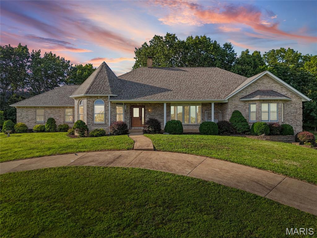 Custom-built executive ranch on 8 +/-scenic acres in Pevely offering over 5,000 sq. ft. of beautifully designed living space. This fully brick home showcases exceptional craftsmanship with an open floor plan, abundant natural light, and panoramic countryside views. A distinctive turret design highlights the breakfast room, while the spacious kitchen, formal dining room, private office, main-floor laundry, and additional full bath provide everyday convenience. The impressive great room features cathedral ceilings and a floor-to-ceiling masonry wood-burning fireplace. The primary suite includes a luxurious bath with jetted tub, separate shower, and generous space. Two additional bedrooms and a full bath complete the main level. The finished walkout lower level offers a large family room, recreation area, fourth bedroom, full bath, and ample storage. Enjoy peaceful mornings from the screened porch overlooking rolling acreage, wildlife, and established gardens. A detached outbuilding provides endless possibilities for equestrian use, hobbies, or additional storage. A rare opportunity to own a thoughtfully designed estate combining privacy, comfort, and timeless quality.