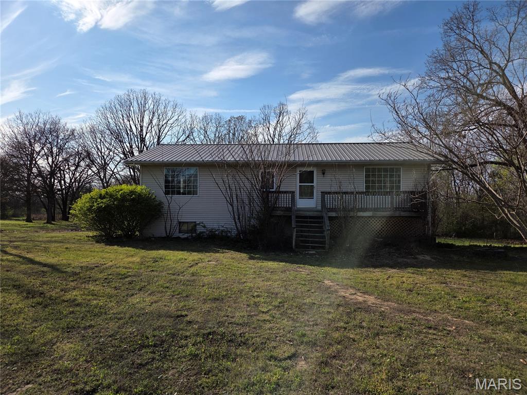 Nestled in a serene setting with stunning views this spacious home offers endless potential for the right buyer. This home sits on 6.5 acres m/l,  has a pond, persimmon trees and lots of visiting wildlife. Inside you will find spacious rooms, ample storage and a main bedroom walk-in closet the size of a small bedroom (13x10). The main bedroom has French doors to the deck that spans the entire back of the house. The deck is also accessible from the living room and has stairs to the patio & backyard. This home has a unique design with the  basement built in 1983 and the upstairs added in 2007. While this home could benefit from some TLC, it is the perfect opportunity to make it your own.Other features include, circle drive, metal roof on house and detached garage and a chicken coop.