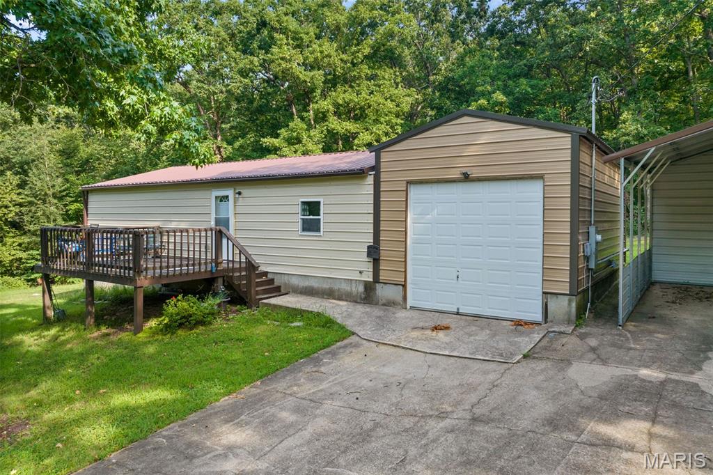 Welcome to the perfect blend of modern living and industrial utility. Built in 2022, this pristine 2-bed, 1.5-bathroom "Shouse" (Shop-House) is situated on nearly an acre of land, offering a rare sanctuary where privacy meets ultimate convenience. Located just moments from premier shopping, dining, & entertainment, this property provides a secluded feel without sacrificing accessibility. The residence is designed for durability & low maintenance, featuring high-quality metal siding, metal roof, & an inviting open deck surrounded by mature trees. Inside, the space is fresh and modern, but the true highlight lies in the expansive shop and garage facilities. A car enthusiast or mechanic’s dream, the property includes a 2-car attached garage, a 1-car detached garage, a carport, and an RV pad with full hookups. NO HOA restrictions &nearly an acre to roam, the home offers incredible expansion capabilities for those looking to grow. Whether you need a professional-grade workspace, secure storage for your lake toys, or a stylish, minimalist residence, this property delivers. Move-in ready & available now—come experience this unique lifestyle!