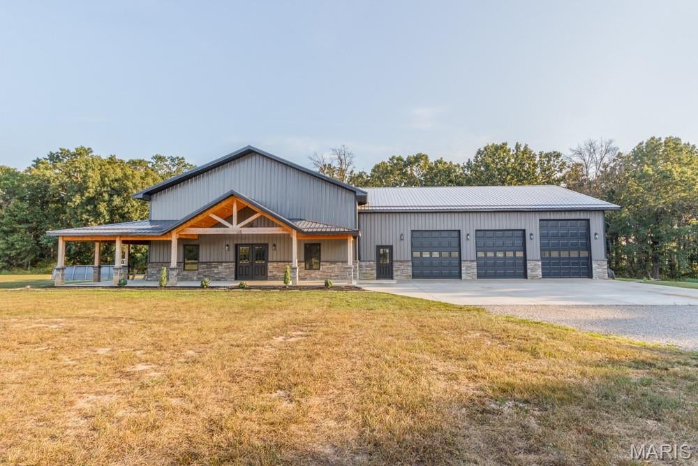 Welcome to this incredible new barndominium nestled on approximately 35 beautiful acres just north of town, only minutes from the city limits, with convenient blacktop access. Offering approximately 3,880 square feet of living space, this impressive home features 5 bedrooms and 3.5 baths and combines modern luxury with the comfort and functionality of country living. Built with efficiency in mind, the home features spray foam insulation and high-end finishes throughout, including custom cabinetry, granite countertops, and durable epoxy flooring. A walk-in gun room provides secure storage, while the massive heated and cooled 50'x50' garage offers an abundance of space for vehicles, recreational equipment, hobbies, or a workshop. One of the standout features is the approximately 1,200-square-foot covered porch overlooking the beautiful acreage and large stocked pond. The pond is fully stocked with bass, crappie, and bluegill, providing an incredible setting for fishing, relaxing, and enjoying the outdoors. With its combination of a stunning new home, exceptional garage space, beautiful acreage, stocked pond, blacktop access, and close proximity to town, this property truly checks all the boxes. Whether you're looking for a private country retreat, a place to enjoy the outdoors, or simply room to spread out and enjoy life, this is truly a small piece of heaven that you won't want to miss!