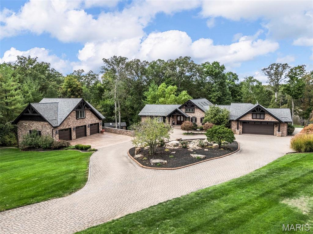 PRICE REDUCED! DON'T MISS OUT ON THIS GREAT OPPORTUNITY! 
Welcome to 9 Woodview Drive, a rare opportunity to own one of Lake St. Louis’ most distinguished waterfront estates an architectural masterpiece blending Old-World craftsmanship with modern elegance. Positioned on 5.85 acres of manicured grounds and majestic oaks, this 6,558 sq. ft. custom residence commands breathtaking panoramic lake views from the most coveted shoreline setting on the lake with its expansive outdoor living spaces featuring a 3-car detached garage with an additional lower level 2 car oversized garage offering an excellent space to store your boat off season. An infinity-edge Gunite pool, and a 20' x 50' two-slip dock with the largest amount of flat useable property on the entire lake.
Inside, every detail reflects impeccable craftsmanship. Rich walnut, granite, soaring cathedral and, and custom millwork elevate each room. The gourmet kitchen is equipped with top-tier appliances, custom cabinetry, a walk-in pantry, and an inviting hearth room. Multiple gathering spaces, including a stunning great room with panoramic views, large hearth room, and glass-enclosed porch offer luxurious comfort and effortless entertaining.  The home includes serene main-level primary suite boasting a spa-inspired bath with whirlpool tub, separate shower, dual vanities, and an elegant double-sided fireplace that overlooks the lake with three additional bedroom suites, a full walk-out lower level complete the interior. The property features numerous skylights, French doors inviting natural light throughout the home. The estate’s lush landscape is enhanced by a gazebo, screened porch, covered, and open patios, and meticulous landscaping that blends indoor and outdoor living seamlessly. This home offers endless surprises around every turn.