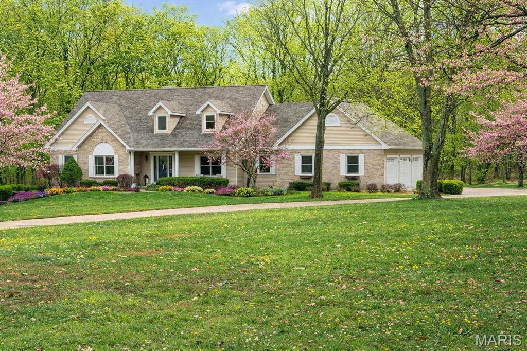 Set on 3 beautifully landscaped acres surrounded by mature trees, this exceptional story-and-a-half residence blends timeless architecture with the warm sophistication of a Ralph Lauren–inspired interior. Rich wood floors, custom millwork, and thoughtfully designed spaces create a home that feels both refined and welcoming. A dramatic two-story foyer makes an unforgettable first impression, flanked by a private executive office with custom built-ins, electric fireplace, and French doors, and an elegant formal dining room designed for entertaining. The heart of the home is the stunning great room, anchored by a fireplace and framed with custom built-in bookcases. French doors open to a spectacular all-window sunroom, filling the home with natural light and creating seamless views of the private, tree-lined property. The sunroom leads to an expansive maintenance-free deck, perfect for morning coffee or evening gatherings overlooking the peaceful landscape. The gourmet kitchen features rich cherry cabinetry, double ovens, a center island with cooktop and seating, and a spacious breakfast room with additional deck access, making indoor-outdoor entertaining effortless. The main-level primary suite is a true retreat, complete with its own fireplace, dual walk-in closets with custom organization systems, and a beautifully remodeled spa bath featuring adult-height double vanities, illuminated mirrors, a freestanding jetted soaking tub, and an oversized tiled shower. Upstairs, two generous bedrooms and a stylishly updated bath provide comfortable accommodations for family or guests. The walk-out lower level is nearly fully finished and ideal for multigenerational living, offering a kitchenette, full bar with seating, fireplace lounge area, game or dining space, exercise room, two additional bedrooms, and a full bath. One area has been thoughtfully designed to easily convert into a private theater room complete with buffet space and theater lighting. Outdoor living continues on the covered patio and extended entertaining area, all surrounded by lush landscaping and serene wooded views. Meticulously maintained and beautifully updated throughout, this extraordinary property offers luxury, privacy, and flexibility just minutes from everyday conveniences. Oepn House Sunday, March 22nd from 2-4pm.
