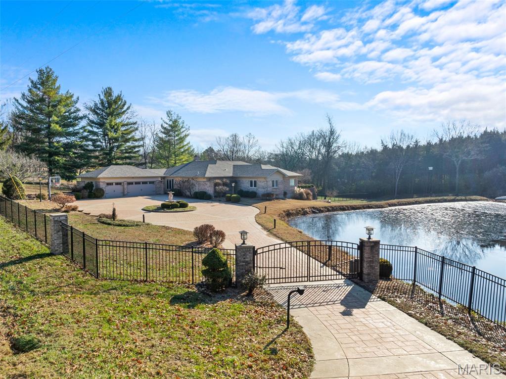 Prestigious gated entry with stamped and colored concrete that surrounds beautiful circular landscaping and a water feature is only the start of this signature home located at the entrance to FCCC. It sits on 3.4 acres that is about half open with a pond and half wooded. Inside there is aprox 4290 sqft on the mail level that includes 5 bedrooms and 3.5 baths. Once inside the main living area you get an immediate view of all this home offers. Sit by the fireplace or relax in the large living space. Beyond that opens to a huge sunroom with indoor pool featuring swim jet. The sunroom also has a built-in hot tub for additional relaxation or fun. Aside the pool area is a 16x25 home gym with rubber flooring. Out back is a elevated 18x25 stamped and colored concrete patio for entertaining or watching the kids or dogs explore the large fenced in back yard. Spacious en-suite features walk in shower with separate soaking tub and custom shelving and drawers in the his and her walk in closets. Downstairs you will find additional finished space that features a bar, another living room, a wine storage room, a 7x10 fully encased concrete safe room with Browning Steel Door, another full bath and additional storage. This home is heated and cooled in three separate zones and was built to last with 2x6 exterior for exceptional temperature regulation. Too many qualities to list them all, schedule today!!
