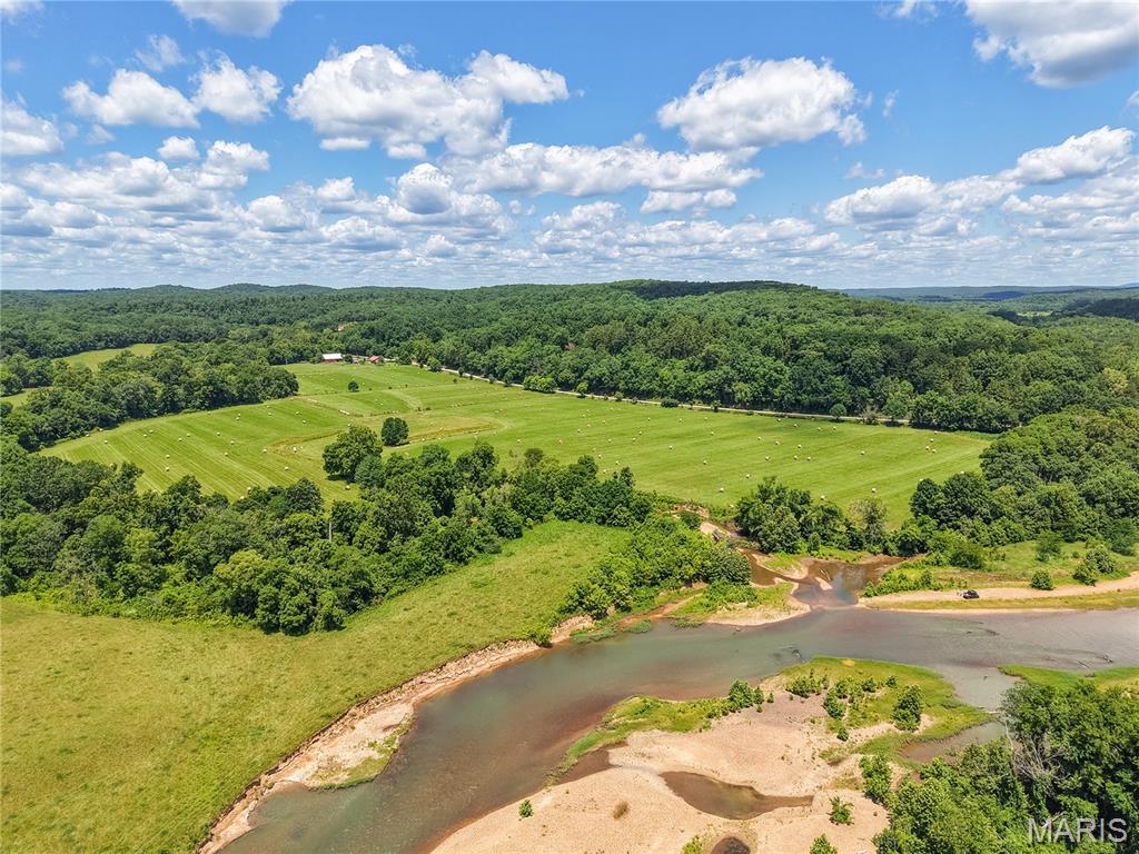 It's rare to find a property that checks every single box, but this 147.8 acre +/- tract manages to pull it off. Offering an unmatched mix of privacy, convenience, and rugged natural beauty, this land features over 1900 feet of black river frontage, easy highway access and a creek that runs through the property. Best of all, it is bordered on the north and south sides by protected National Forests and government recreational area, giving you a massive permanent recreation area with abundant deer, turkey and wildlife. The land itself is highly versatile, with good soil and a two-thirds split of open pasture and maturing timber. It's fully set up for self-sufficiency and livestock, featuring a well pump dedicated to the cattle and the main house. You'll also find a functional working barn for storage or livestock, plus a traditional, native stone smokehouse.

For living space, the property features a comfortable, well-built 1,800 square foot traditional style home that fits great into the landscape. Between the direct river access on your own land, creek running through the middle and the added bonus of a public boat ramp located just inside the neighboring government recreation area, outdoor recreation is right at your doorstep. Whether you're looking to run a cattle operation, establish a private hunting retreat, or just find a beautiful, quiet place to call home, this property is a rare find.

Showings by appointment only. Contact us today to schedule a tour.