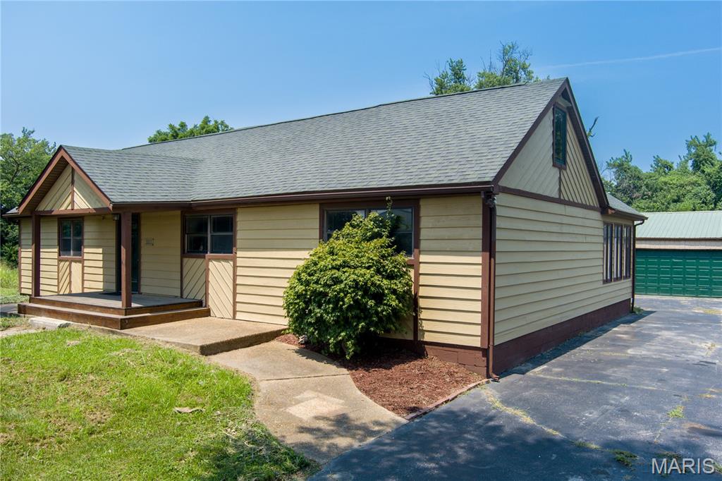 Ready to pack those bags and move to the country! 4-bedroom, 3-bathroom retreat sits on 8.2 acres. Property is on large, wooded lot & features small trail, a storage house.  1.2 acre lot with small storage shed is being sold with the home ( Address is 5201 Old Alton Edw R), Edwardsville Home has Laminate flooring a bright, kitchen with fresh paint, new flooring & all appliances stay. The Living room / bar opens to a & three season room, perfect for outdoor relaxing, dining & enjoying the scenic surroundings. Main-floor laundry is enhanced w/additional cabinetry, utility sink, & fresh paint. Generously sized primary suite w/walk-in closet & soaking tub, primary bedroom does have double glass doors leading to a 15x14 deck. Deck is across back of home and continues with another 25x18 extension off sunroom down to master bedroom. Finished walkout basement allows you to back up to nature & extend your entertaining area w/a covered patio or stay in & snuggle by the fireplace.  Spacious 4th bedroom offers privacy w/ its on full bathroom on 3rd level of home. On the 3rd level there is also large bonus room. This room has limited heating and cooling.  Plenty of storage too!  OVERSIZED 2-car garage with endless possibilities. Might you need a man cave, private office, recreation room, home gym?