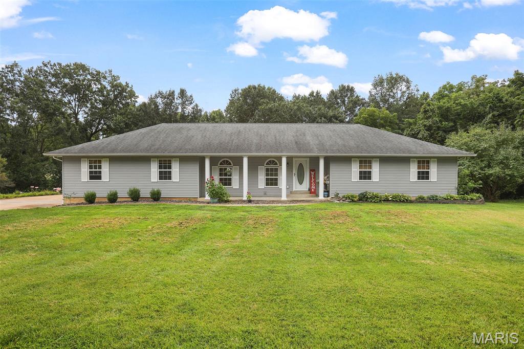 If peace, privacy, and a beautiful setting are at the top of your wish list, this one is worth a look. Nestled on 3.2 private acres in the beautiful Forest Hills Estates subdivision, you'll love the backyard where mature trees, wildlife, a wet-weather stream and peaceful surroundings make it easy to slow down and enjoy home. Whether you're sipping coffee on the welcoming front porch or relaxing on the composite back deck that overlooks it all, this property offers the kind of outdoor setting that's hard to find. Inside, you'll find hardwood floors, an open living room, and a spacious kitchen and dining area full of character. While not the latest trend, the kitchen was thoughtfully designed with quality craftsmanship, tall custom cabinetry, and a layout that's as functional as it is unique. Solid wood doors throughout are another reminder of how well this home was built and cared for. The main level features three bedrooms, including a spacious primary suite with a private bathroom complete with a jetted tub and separate shower. You'll also appreciate the convenience of main level laundry-washer and dryer stay! The bathrooms and laundry room are finished with ceramic tile flooring, offering a clean, classic look. The attached 3-car garage offers plenty of room for vehicles, tools, toys, or extra storage. Downstairs, the huge unfinished walkout basement provides exceptional storage and endless potential for future additional living space, a workshop, hobby area, or whatever best fits your needs. Well maintained, thoughtfully built, and surrounded by nature, this is the kind of place that simply feels like home the moment you pull into the driveway. Expected Active Date 8/13.