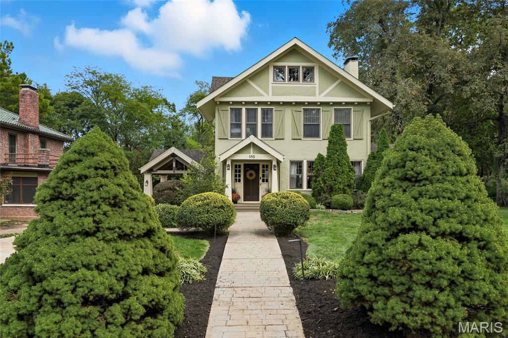 In the heart of Webster Groves, on one of its most beloved tree-lined streets, this charming 5-bedroom, 4.5-bath Tudor offers the perfect blend of character, comfort, and space. From the moment you step inside the spacious foyer, you’re greeted by a light-filled living room with a cozy gas fireplace and French doors that open to a spacious dining room and a sunroom with exposed beams—ideal for working from home or curling up with loved ones. The kitchen is both stylish and functional, with soapstone counters, ample custom cabinets, stainless appliances, and a butcher block island that invites conversation. On the 2nd floor, you’ll find laundry, plus 3 bedrooms and 2 full baths, including a serene primary suite with sitting room overlooking the backyard—perfect for quiet mornings or snowy evenings. With two additional bedrooms and a bonus space on the third floor, there’s room for everyone. Impeccably finished lower level serves as a true extension of the home, featuring a versatile den with Murphy bed—ideal as a guest suite, office, or playroom—plus a spacious family room with bar rail, projector screen, second kitchen, and stunning 3/4 bath. Perfect for entertaining, movie nights, or game days. Outside, nearly an acre of lush, park-like grounds and a 3 tiered deck offer endless possibilities for play, entertaining, or an evening of relaxing. And with its prime location just a short stroll from downtown Webster’s shops, restaurants, and community events, this home combines classic elegance with unbeatable access to local favorites.